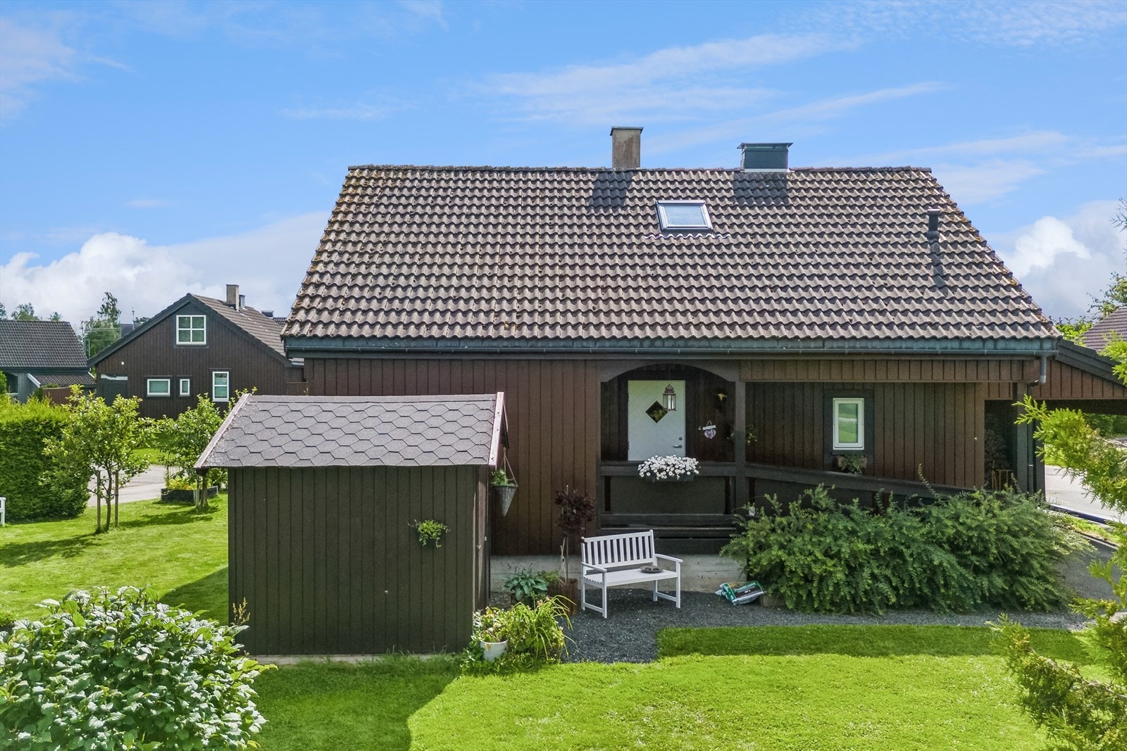 Boligen har inngang via et trivelig, overbygd inngangsparti og det er gruslagt gangfelt frem til uteboden. Galleribilde