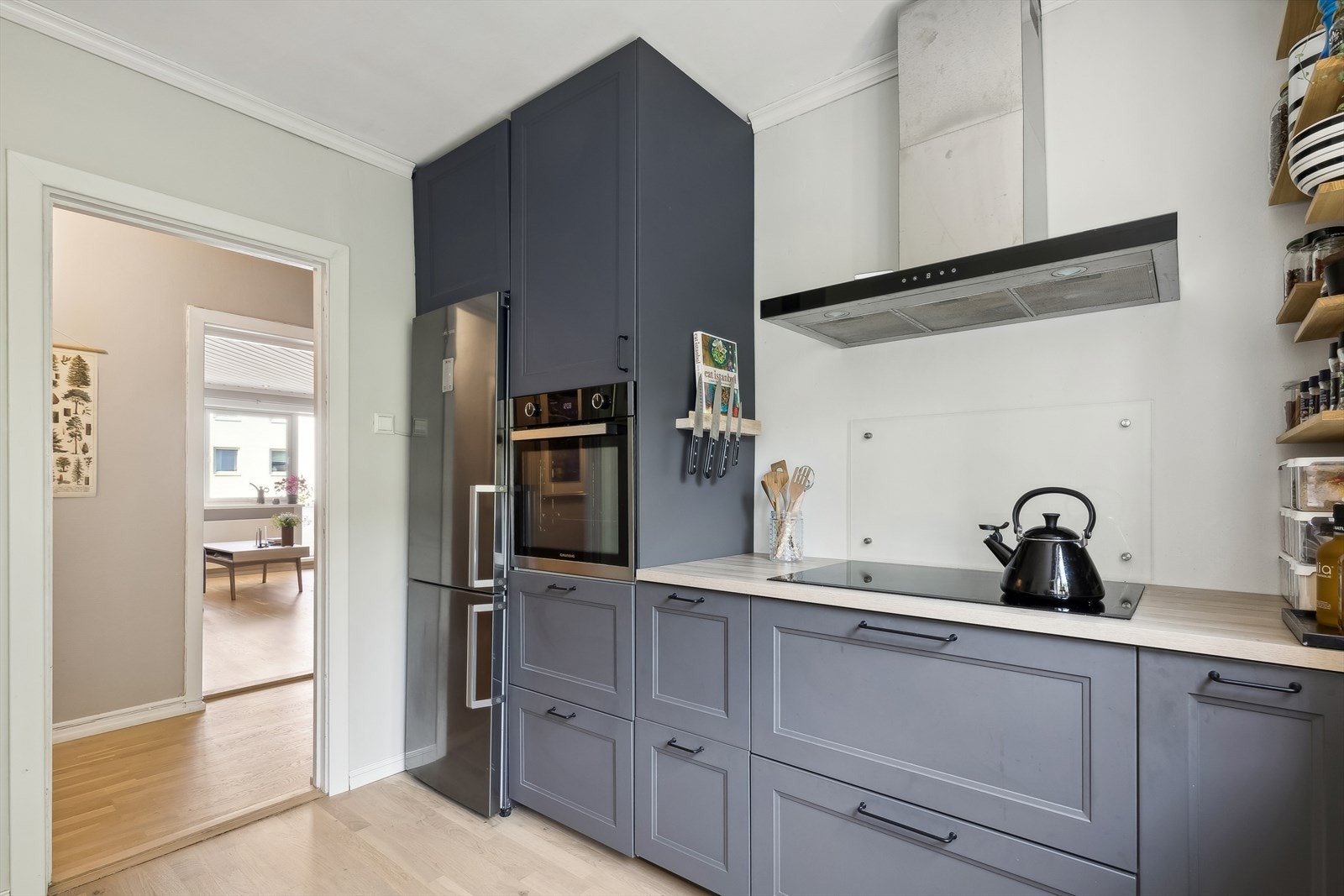 Kjøkkenet er innredet med profilerte malte fronter, laminat
benkeplate og glassplater på vegg over benk Galleribilde