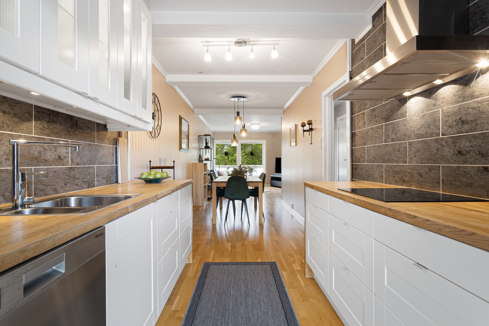 Pent kjøkken med innredning fra Ikea, heltre eik benkeplate og integrerte hvitevarer Galleribilde