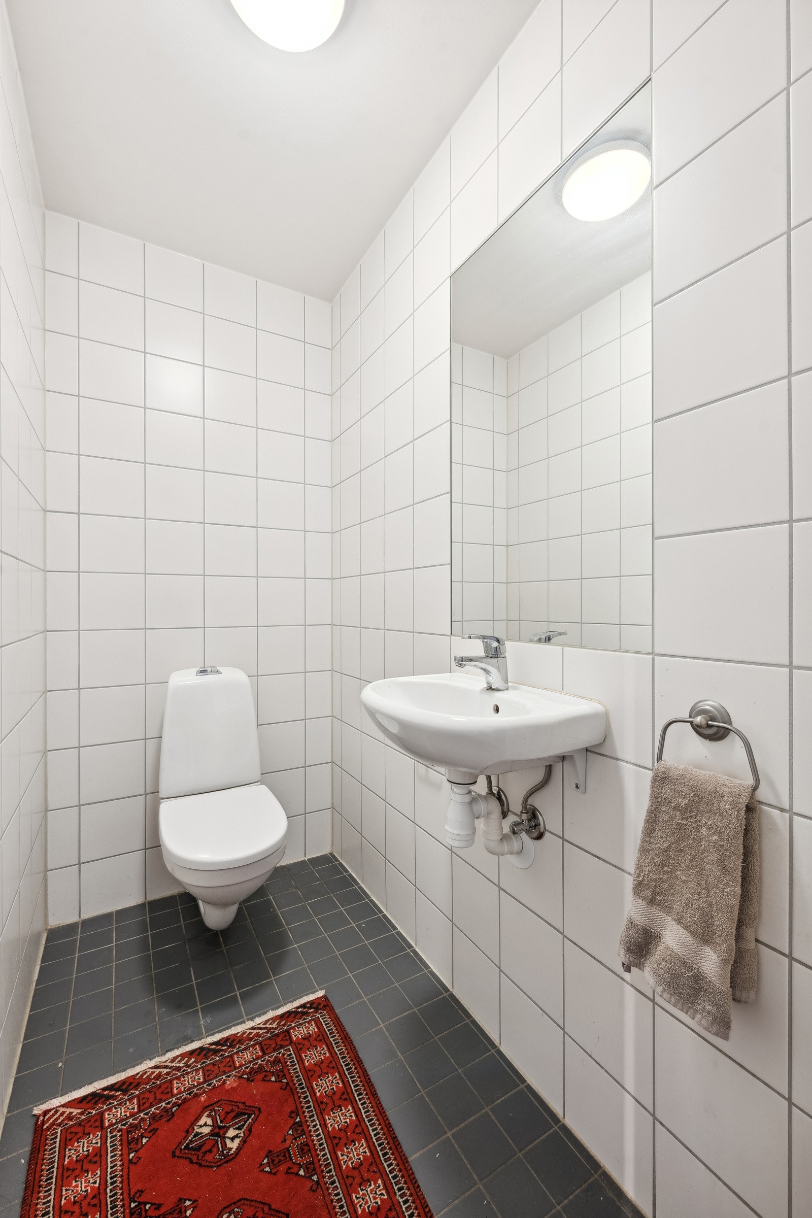 Separat flislagt toalettrom med speil og servant. Galleribilde