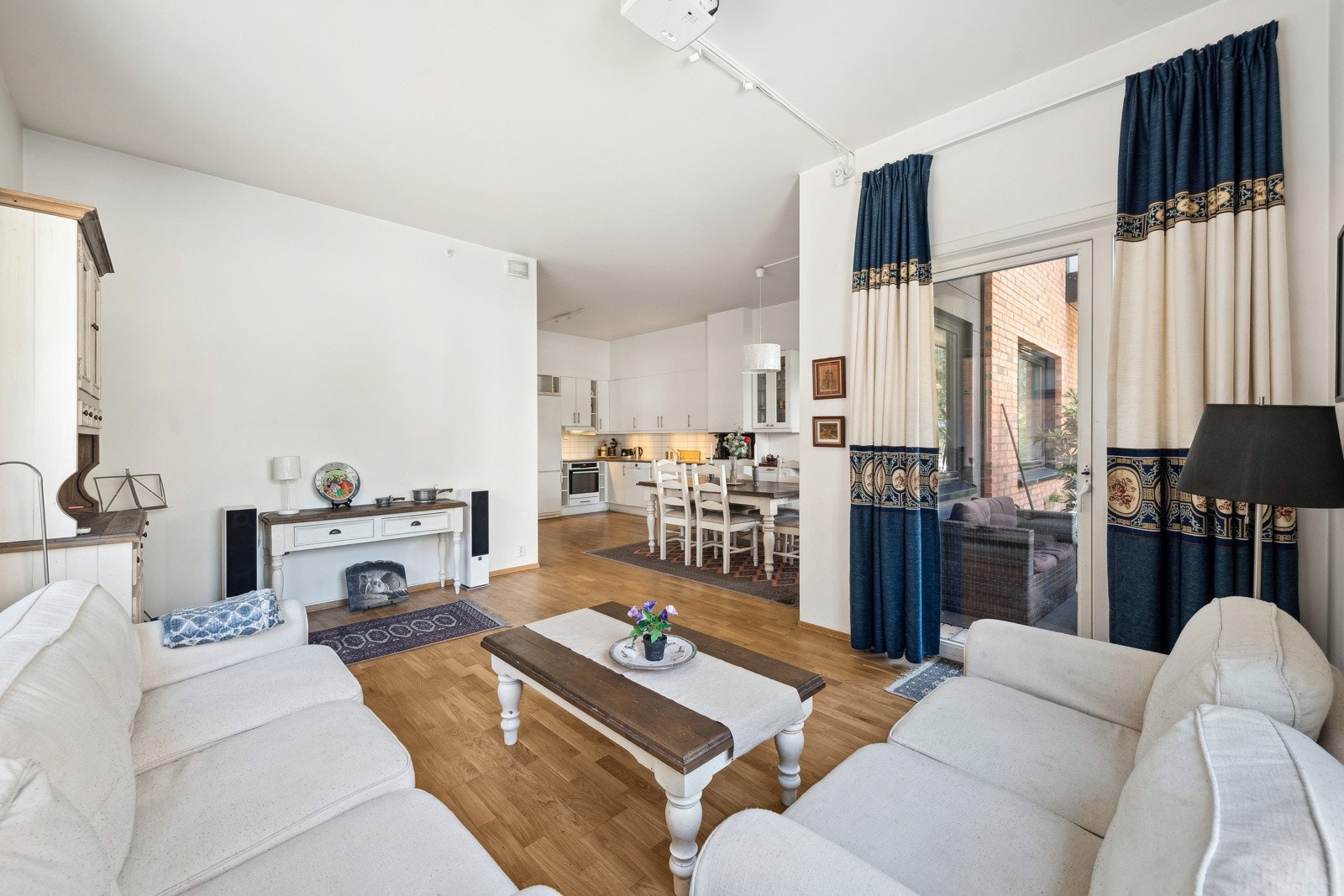 Åpen stue mot kjøkken med store vindusflater som gir godt med lys inn. Galleribilde