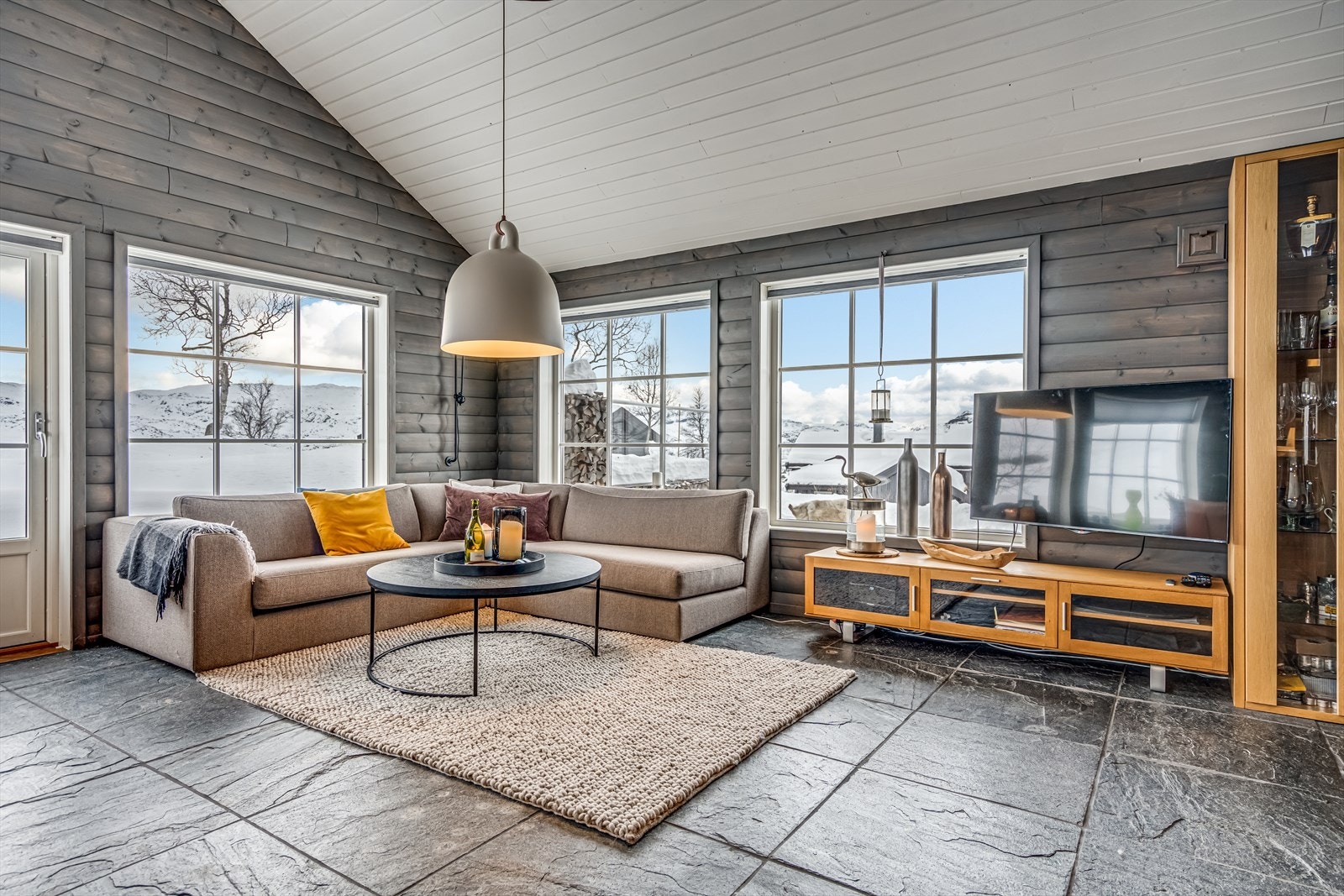 Pen stue med skråhimling og store vinduer som gir godt lysinnslipp og flott utsikt Galleribilde