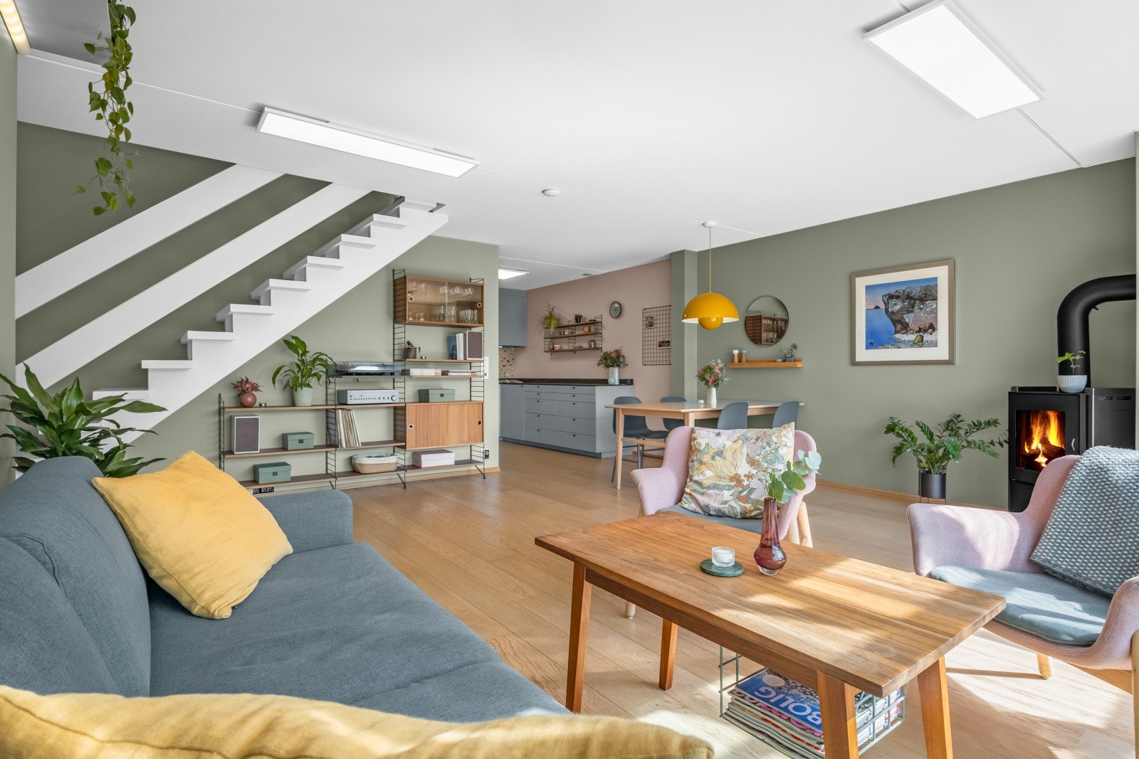 Flott belyst oppholdsrom med plass til stor sofaseksjon, stuebord og tv-møblement. Galleribilde