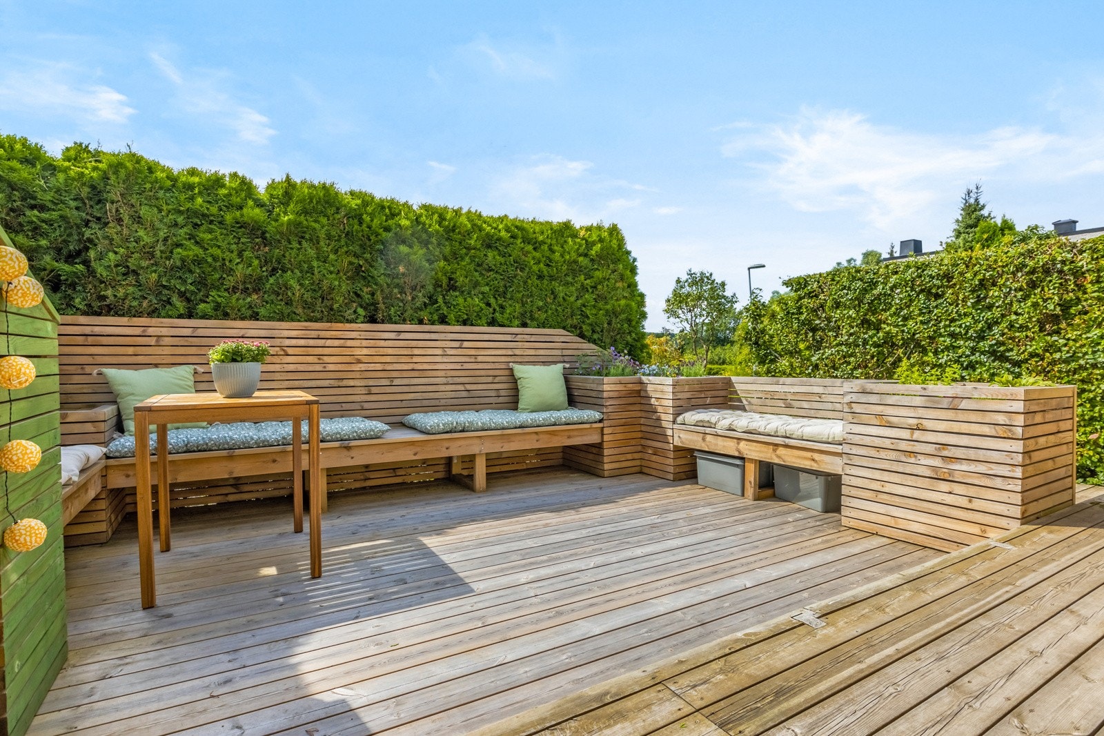 Terrassen har en sosial og godt gjennomført løsning med plassbygde sitteplasser og blomsterkasser. Galleribilde