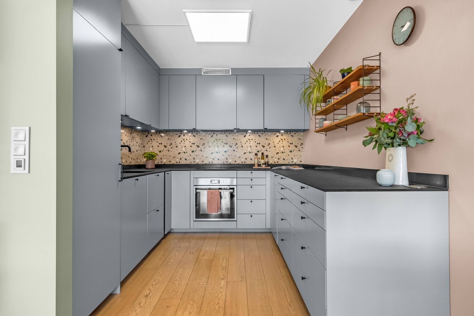 Lekkert og påkostet kjøkken med takhøy innredning. Kjøkkenets utforming byr på godt med skap- og benkeplass. Galleribilde