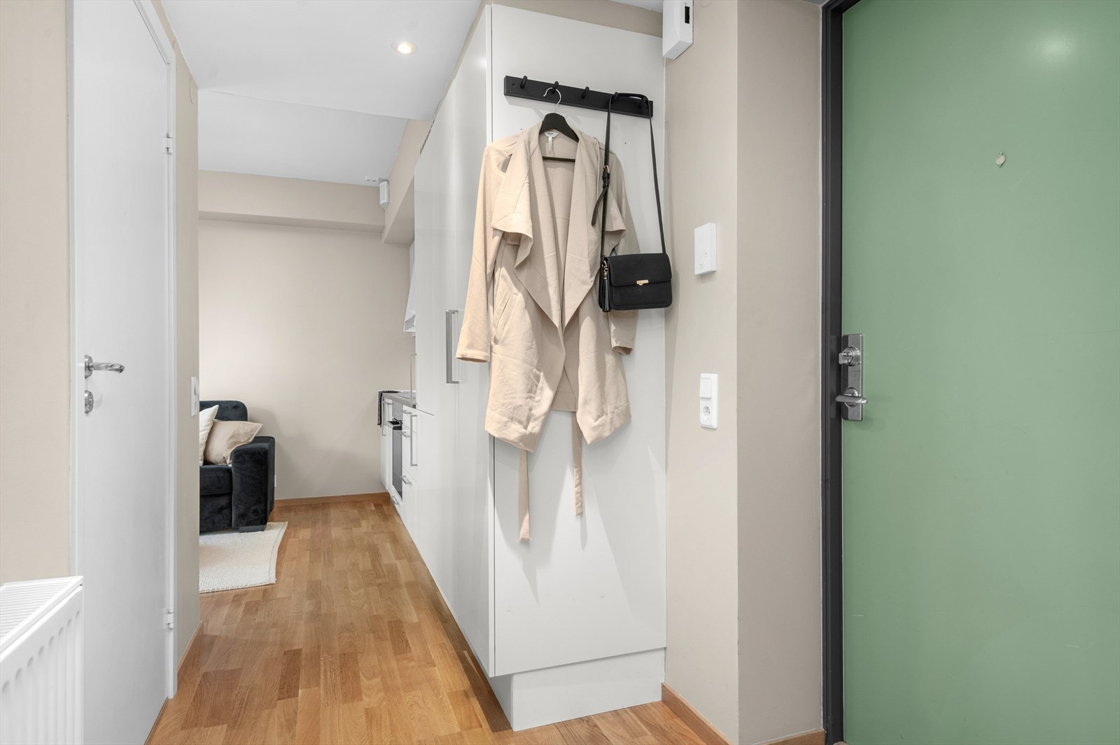 Inngangspartiet er lyst og legger til rette for både kommode og heng for oppbevaring av yttertøy og sko. Alle veggflater i leiligheten er oppmalt i nøytrale og delikate fargetoner i 2024. Galleribilde