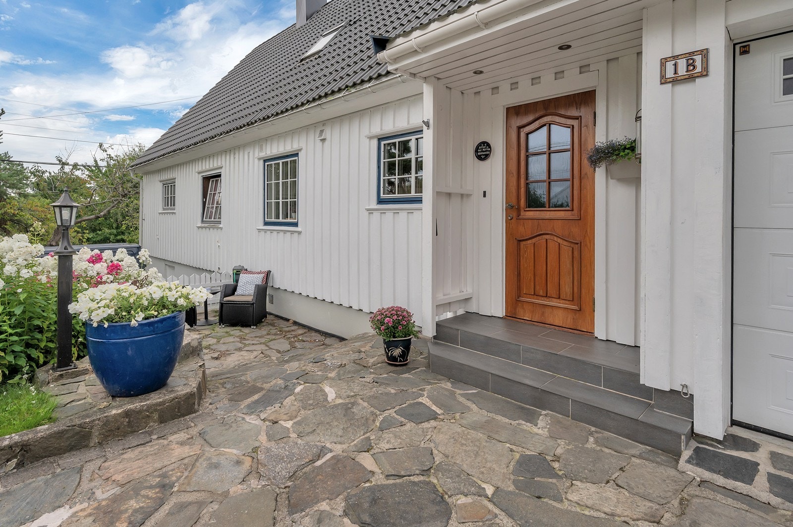 Solrike uteplasser også ved inngangspartiet. Området hvor utemøblene står er også godt egnet til å oppbevare henger (opplegg i garasjen for å dra opp hengeren) Galleribilde