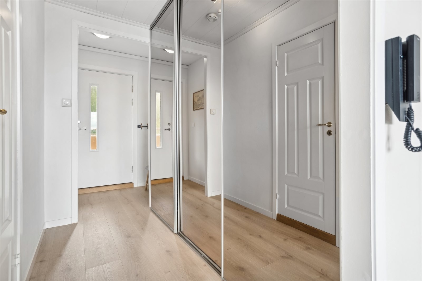 Romslig entré med stor skyvedørsgarderobe Galleribilde
