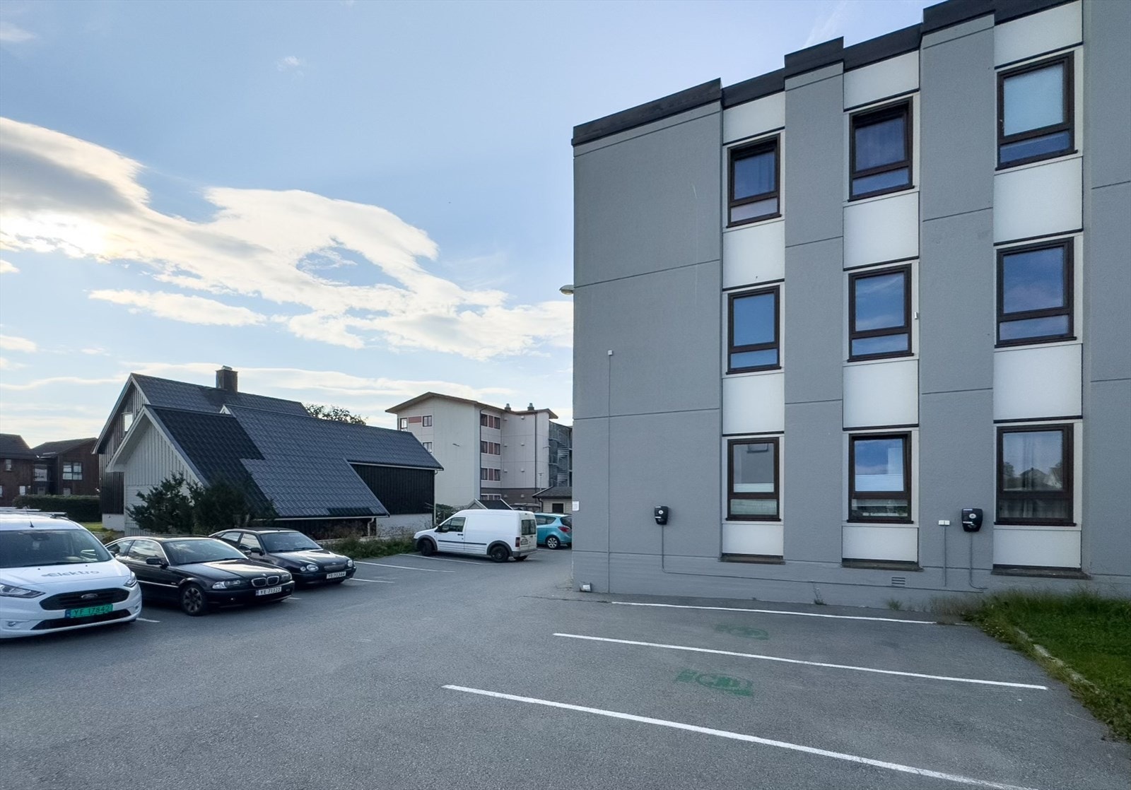 Stor felles parkeringsplass med el-bil ladere. Galleribilde