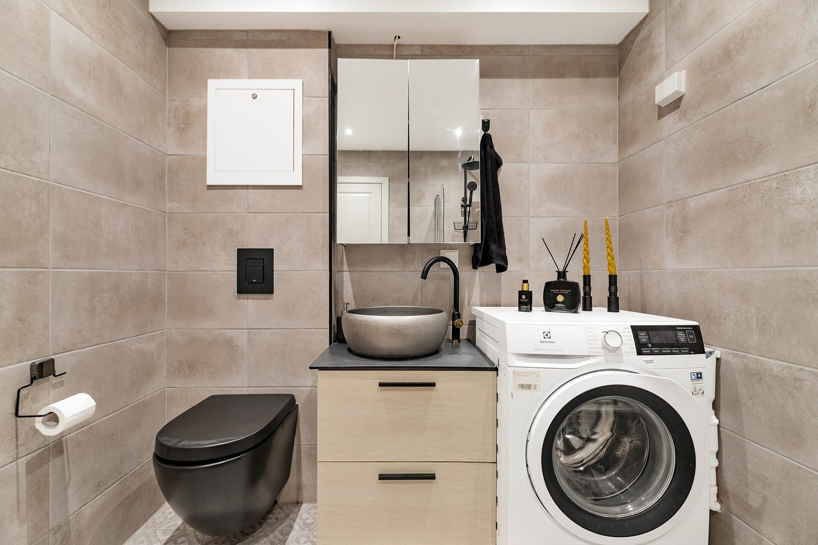 Badet er utstyrt med badekar med dusj og glassvegg, vegghengt wc og servantinnredning med skuffer og overskap Galleribilde