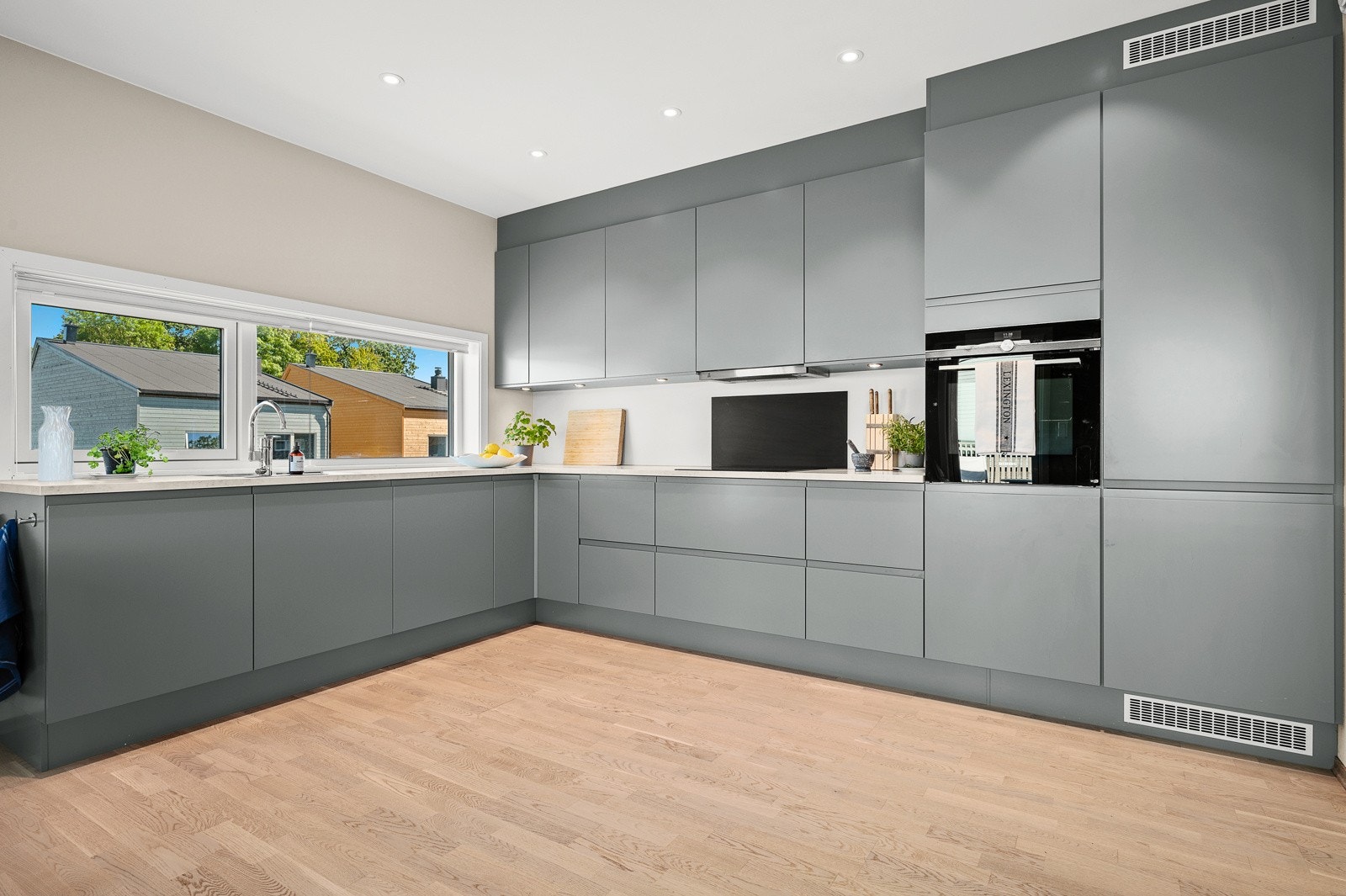 Kjøkkenet er moderne med slette fronter og integrerte hvitevarer Galleribilde