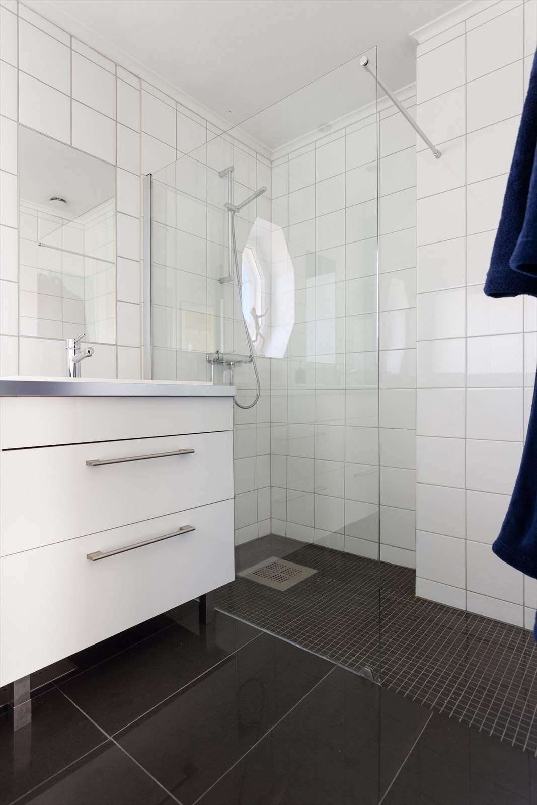 Badet består av vegghengt wc, to servanter med skuffer under og dusj med glassvegg. Damixa armatur. Galleribilde