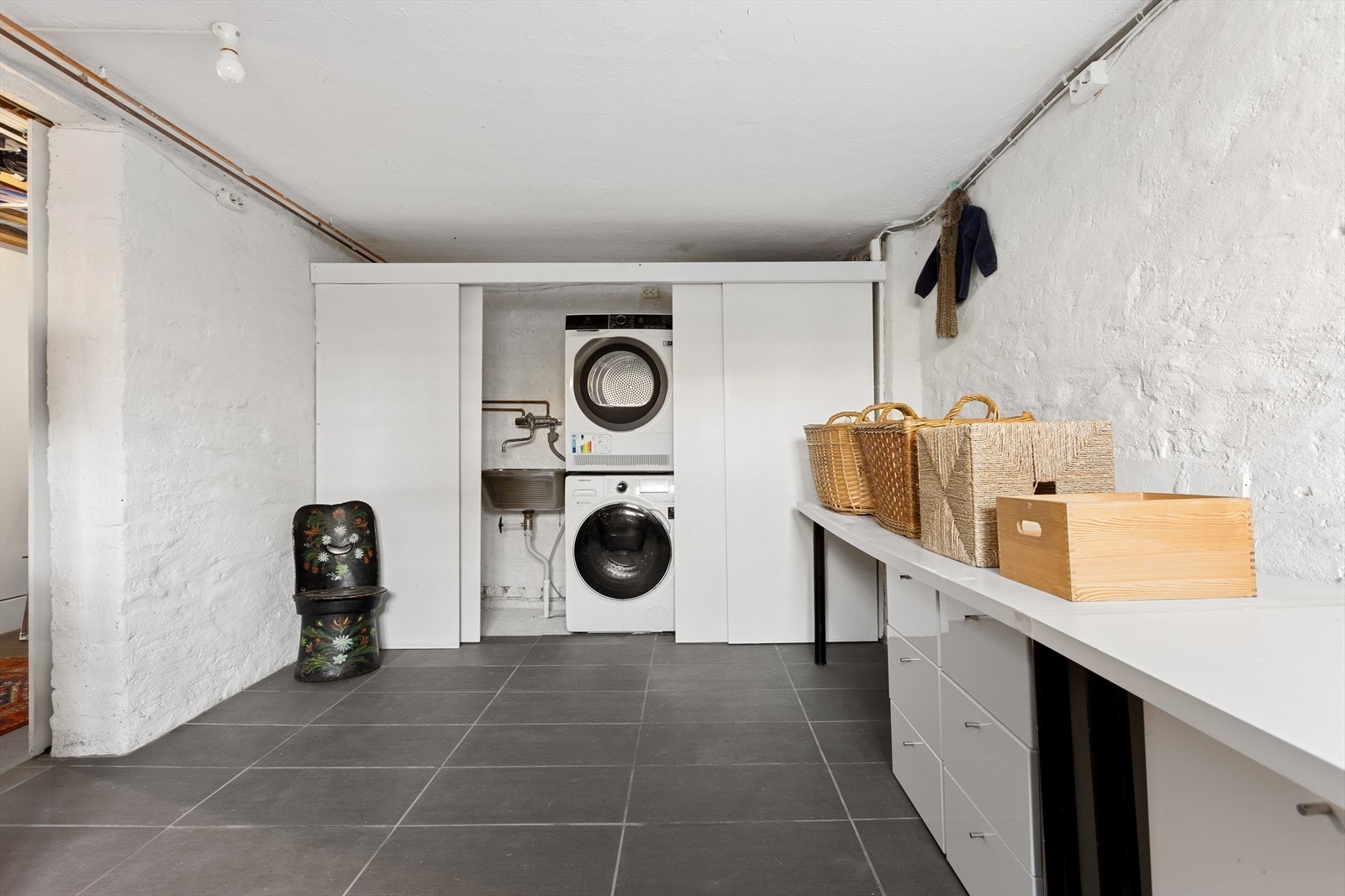 Det er opplegg for vaskemaskin og tørketrommel, samt utslagskum som er fint plassert bak skyvedører. Galleribilde
