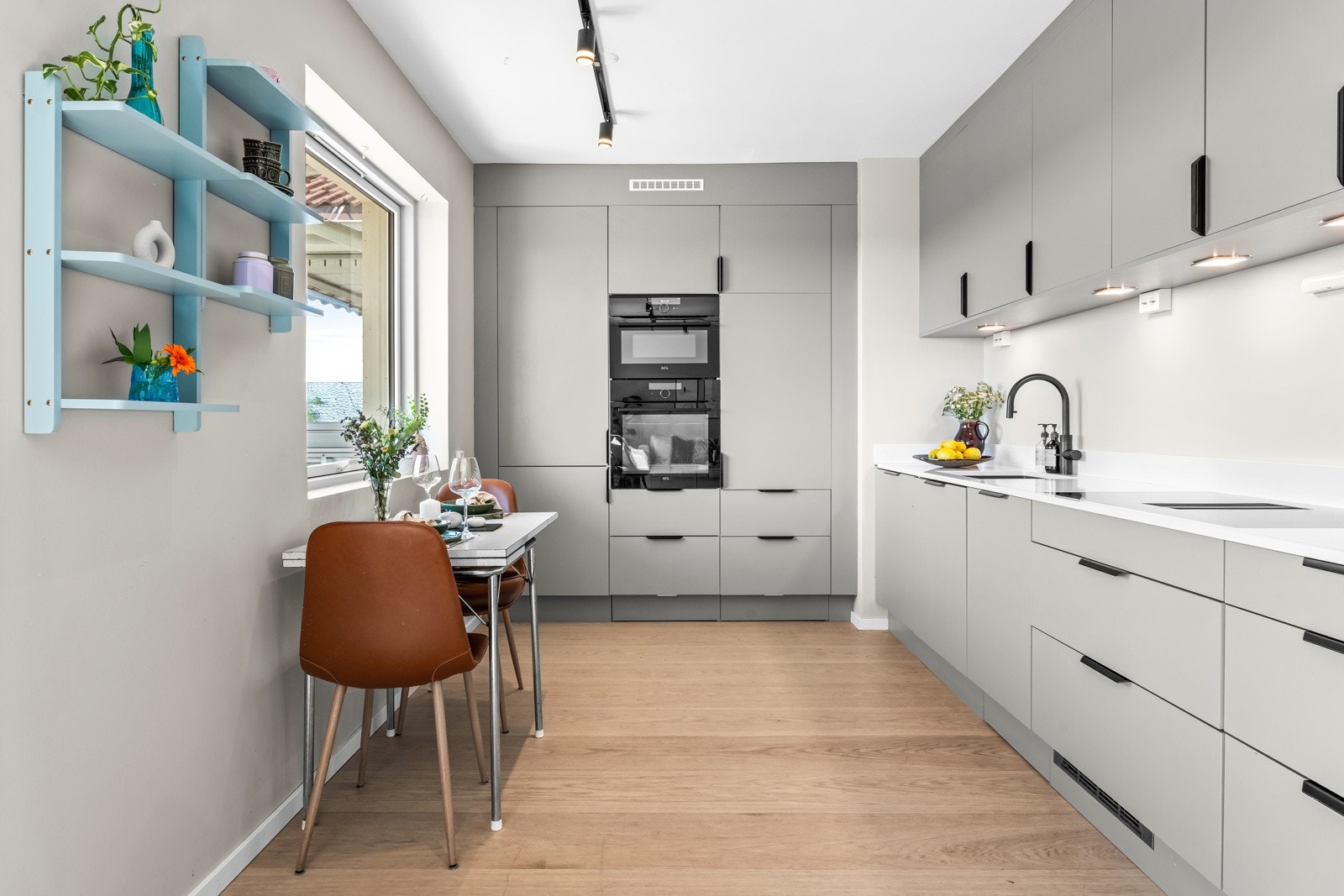 Stilrent HTH-kjøkken fra 2022 i L-form, i en åpen, men tilbaketrukket løsning mot stuen. Galleribilde