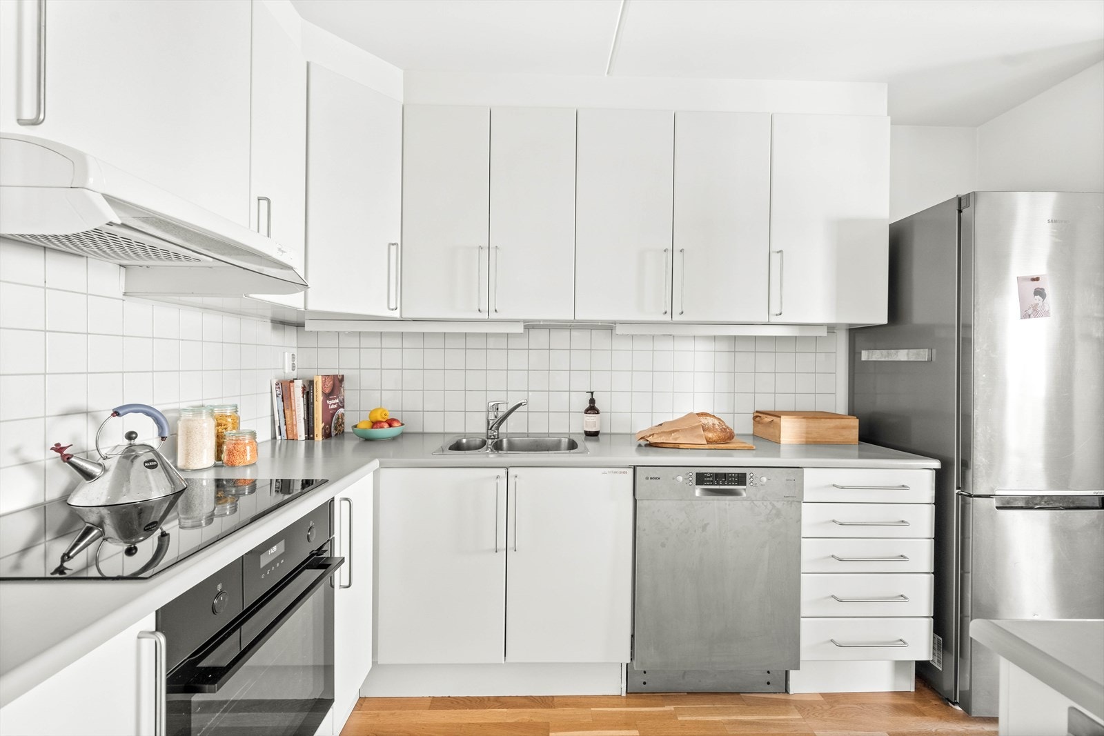 Flott Sigdal kjøkken fra byggeår med fliser mellom overskap, laminat benkeplate og lys under overskap. Galleribilde