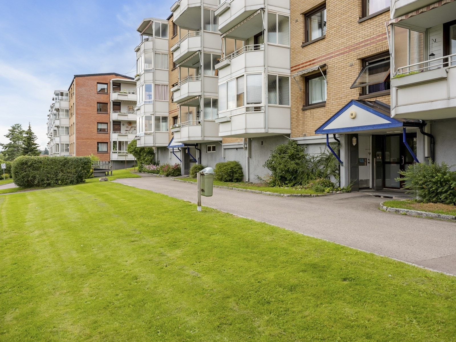 Velstelt inngangsparti med grøntarealer rundt bygningen. Galleribilde