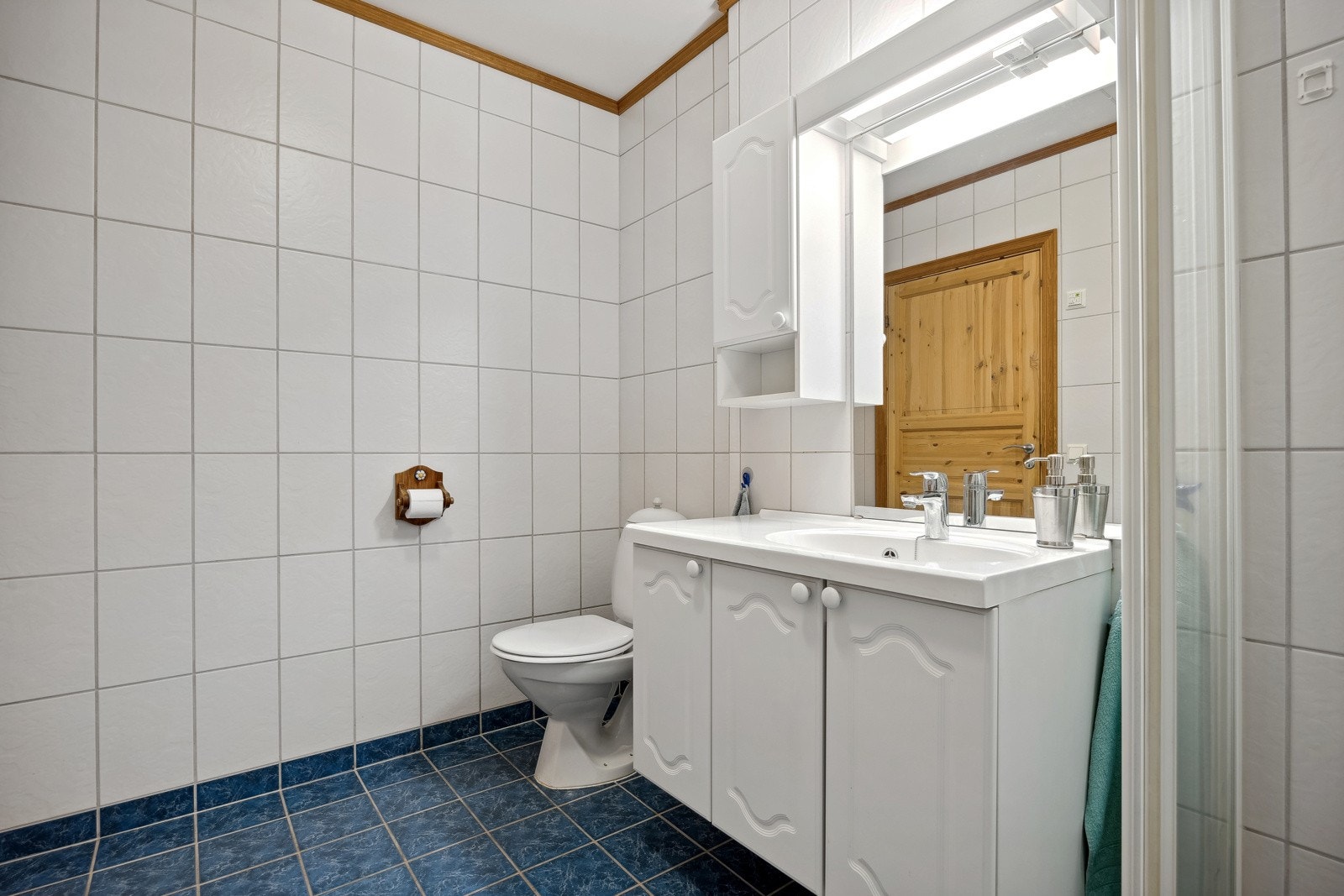 Badet er utstyrt med vegghengt innredning, speil med overlys, Dusjhjørne med dører og gulvstående toalett. Galleribilde