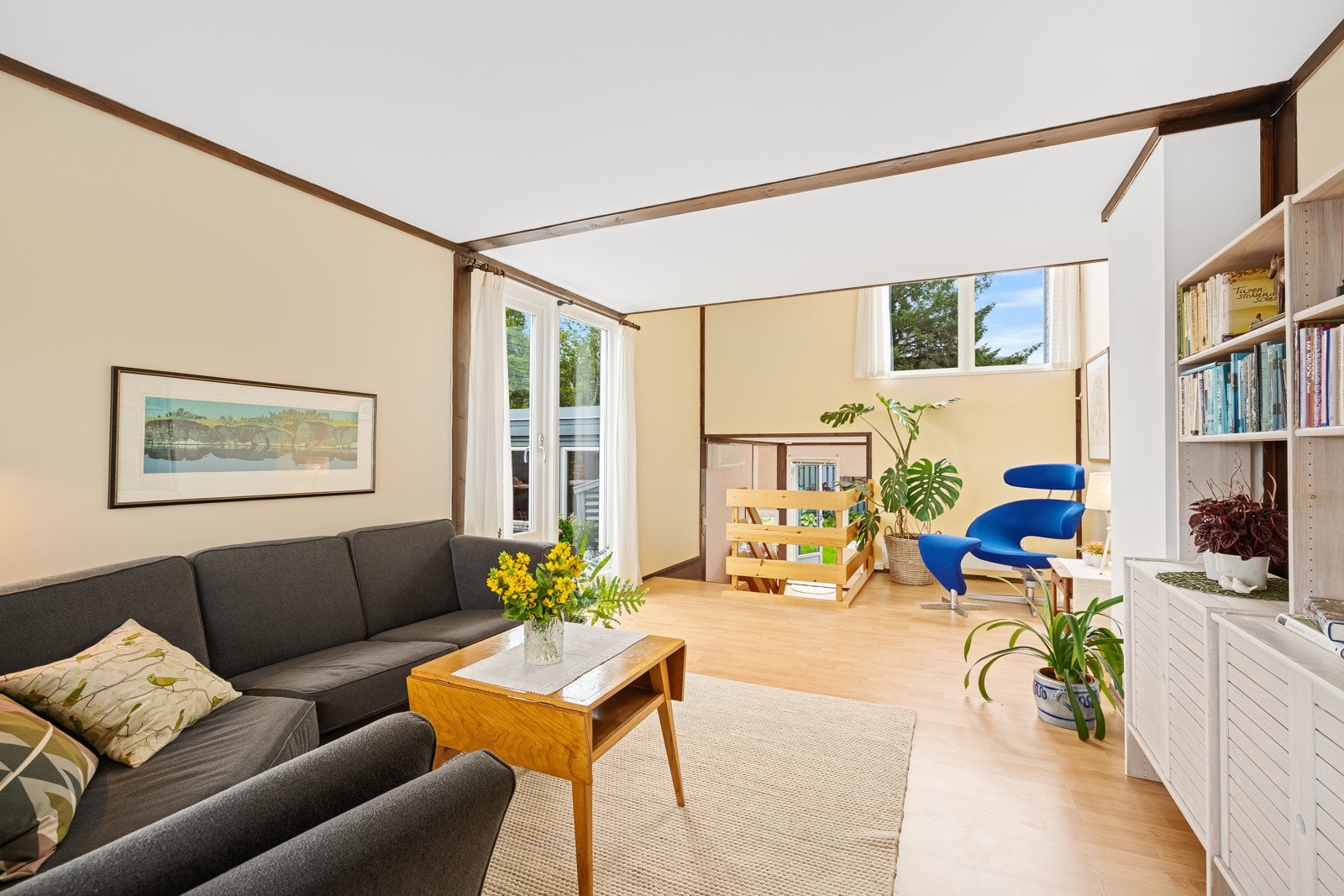 Romslig stue med store vinduer som slipper inn rikelig med naturlig lys. De lyse veggene og den åpne løsningen skaper en luftig atmosfære. Galleribilde