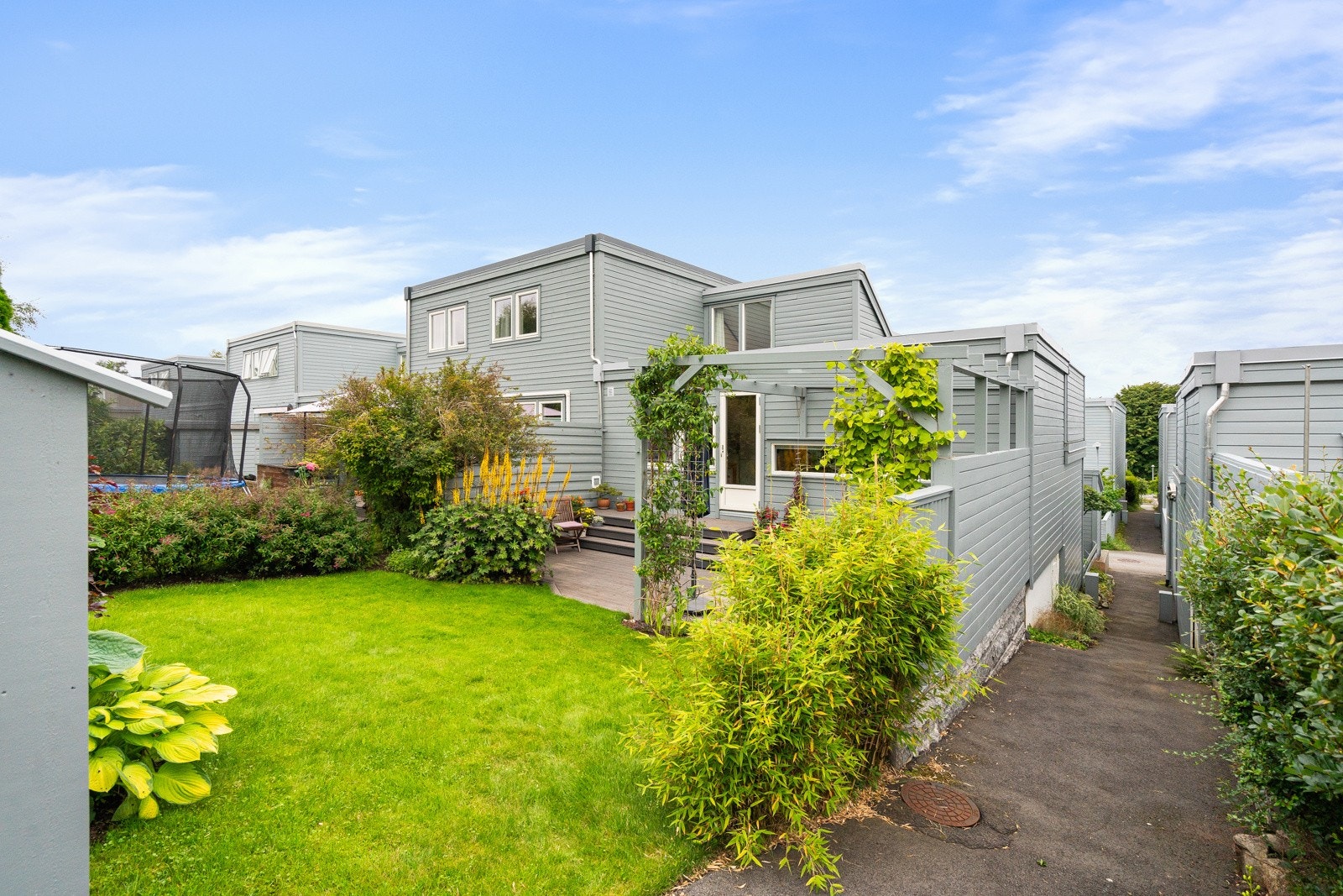 Den grønne og velstelte hagen gir et fredelig og privat utendørsrom. Galleribilde