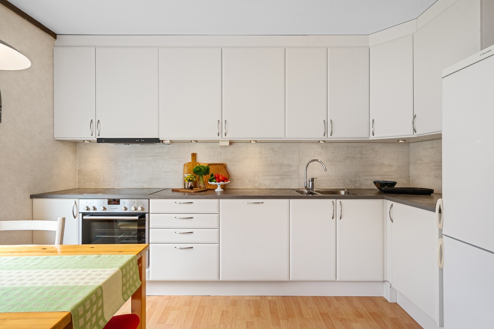 Moderne kjøkken med glatte fronter og laminat benkeplate, oppusset i 2012. Kjøkkenet er utstyrt med oppvaskmaskin, komfyr og platetopp. Galleribilde