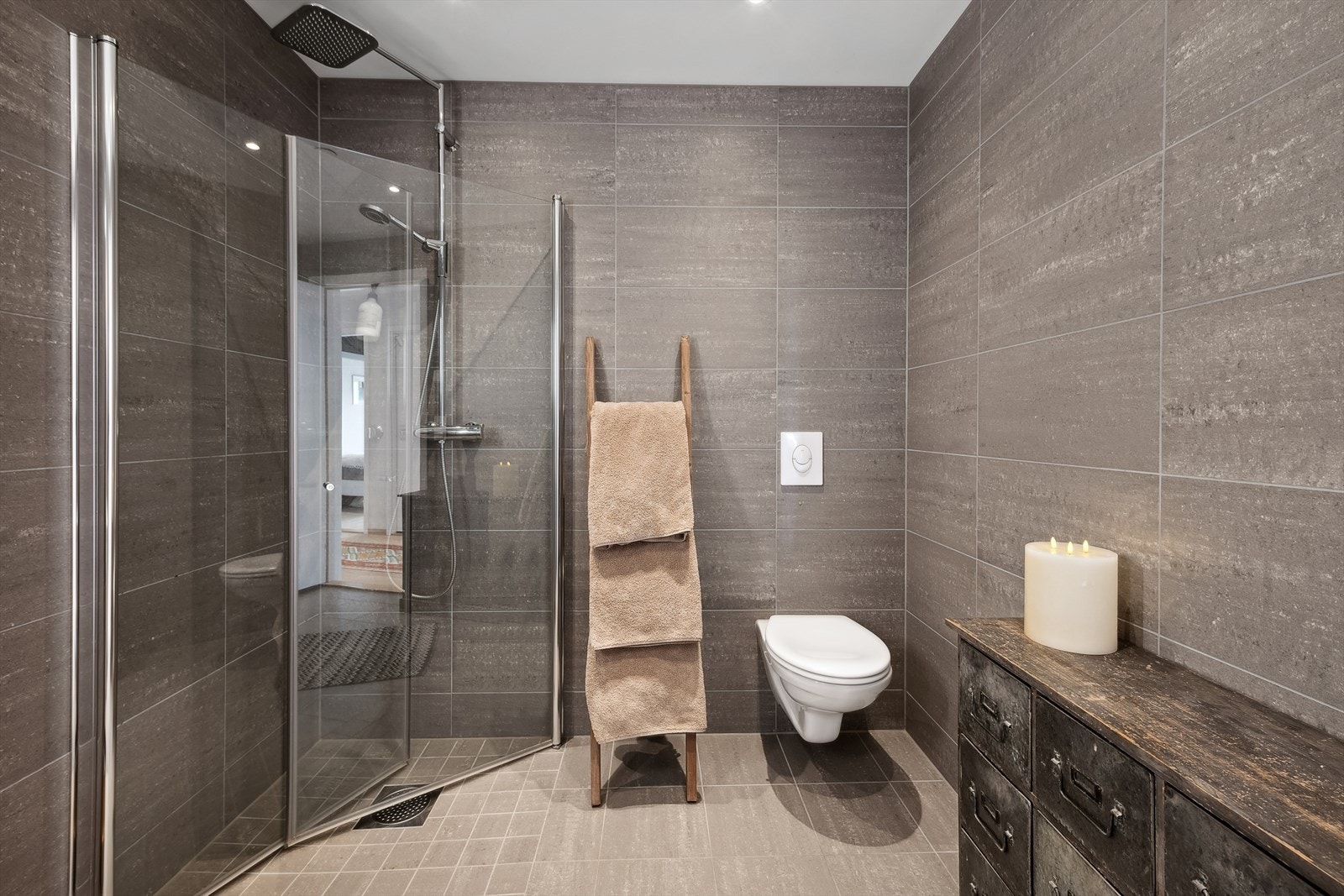 Badene fremstår delikate og har dusjhjørne med glassdører, vegghengt toalett og servant. Galleribilde