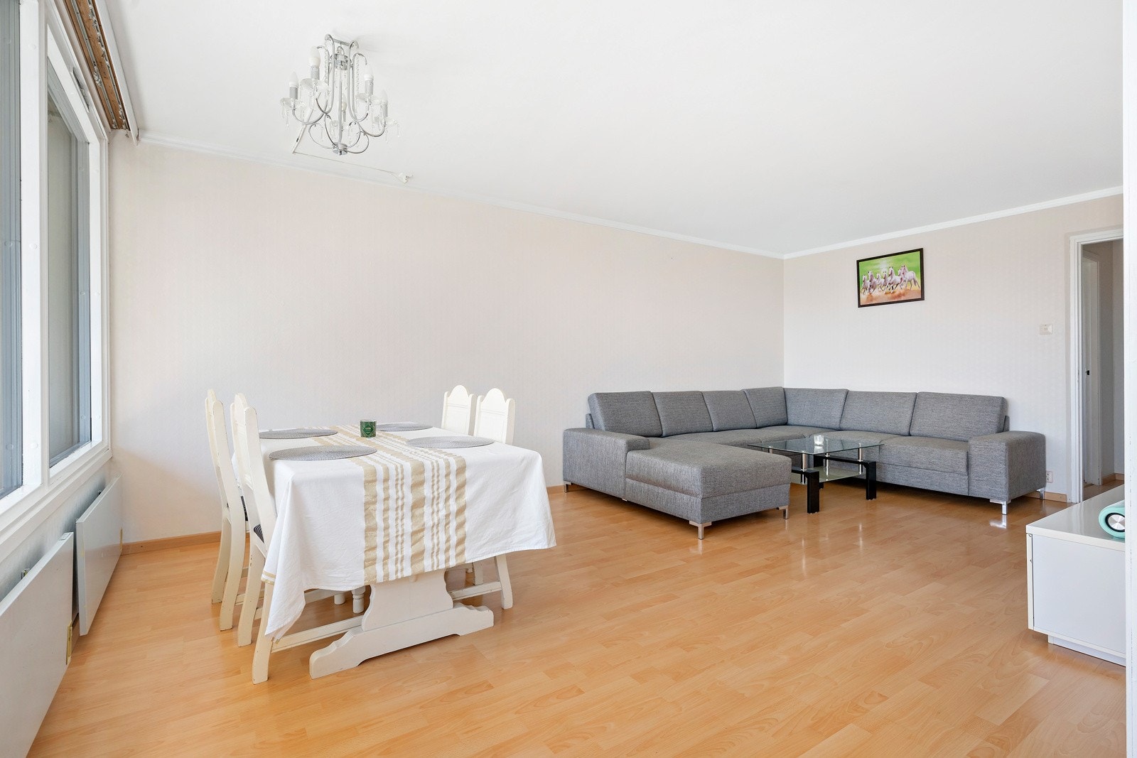 Stuen er romslig med god plass til sofa, sofabord og mediemøblement. Det er ogå plass til en spisegruppe med mange rundt bordet Galleribilde