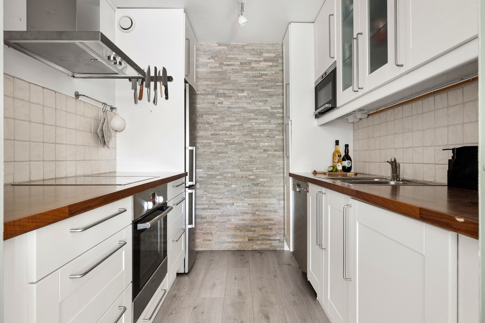 Lyst og pent kjøkken med profilert innredning og slitesterk laminat benkeplate med nedfelt stålkum, ett-greps blandebatteri og induksjonstopp. Galleribilde