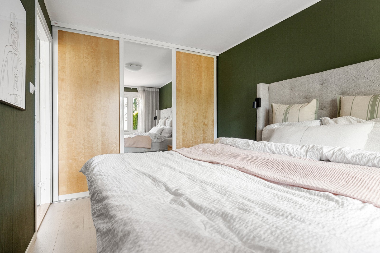 Langs den ene veggen er det en stor skyvedørsgarderobe som gir rikelig med lagringsplass. Galleribilde
