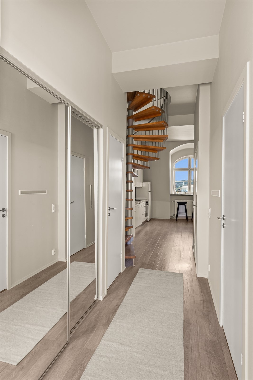 Når du kommer inn i leiligheten møtes du av en lys entré. Her finner du en skyvedørsgarderobe som sørger for gode oppbevaringsmuligheter. Galleribilde