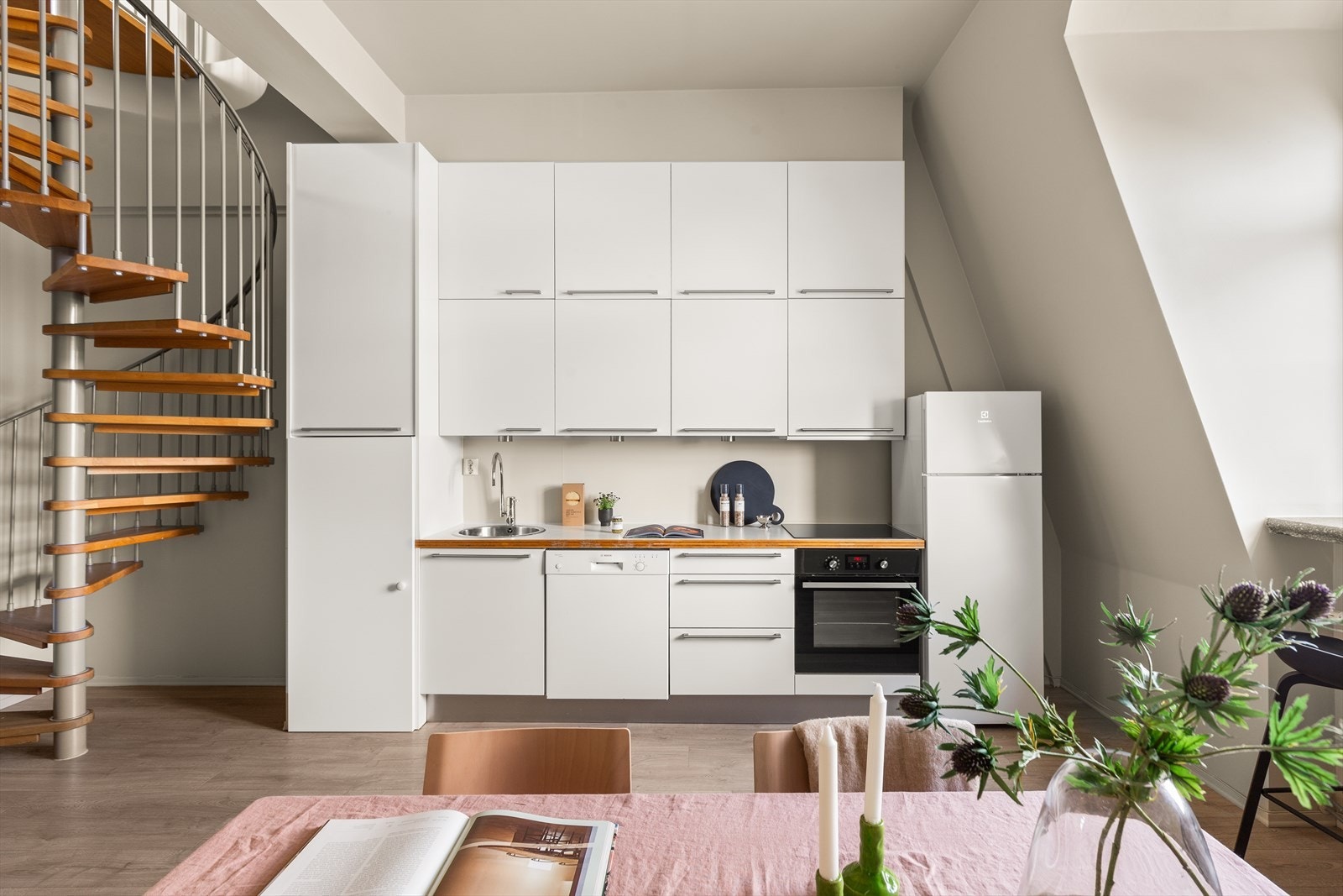 Stilrent og lyst kjøkken som har innredning fra HTH med glatte fronter, samt benkeplate i laminat med nedfelt rund oppvaskkum i rustfritt stål. Galleribilde