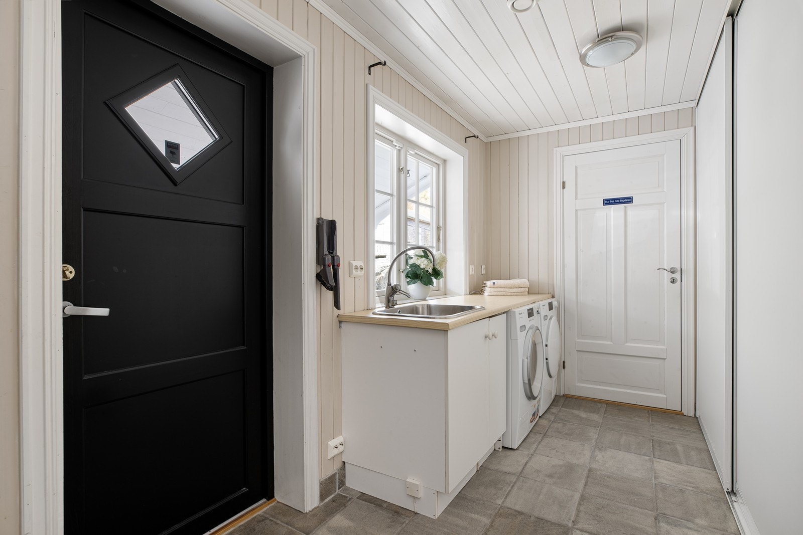 Praktisk vaskerom! Innredet med innredning, opplegg for vaskemaskin og skyvedørsgarderobe med god oppbevaringsplass Galleribilde