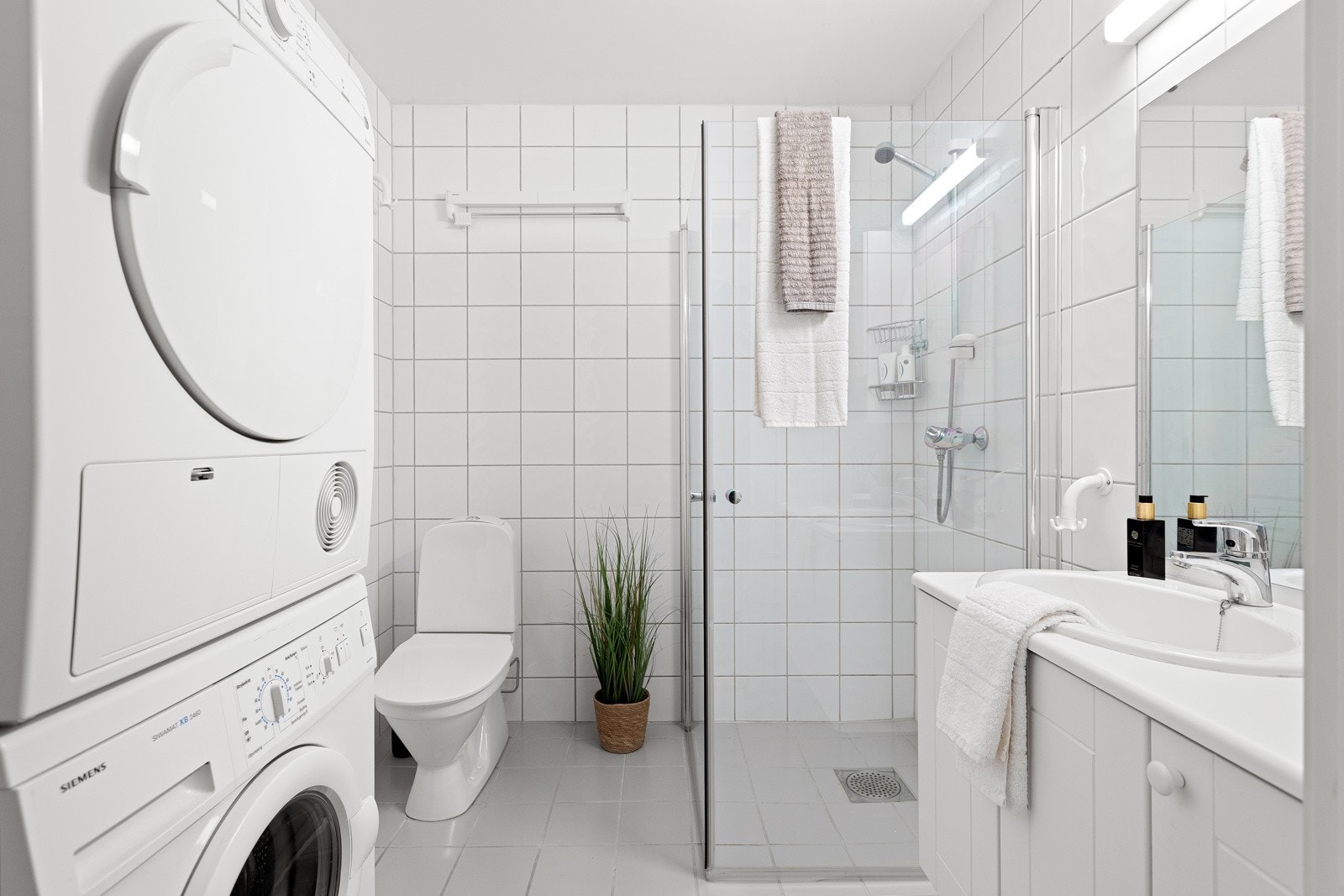 Tidløst baderom utstyrt med dusjhjørne, toalett og baderomsinnredning. Galleribilde