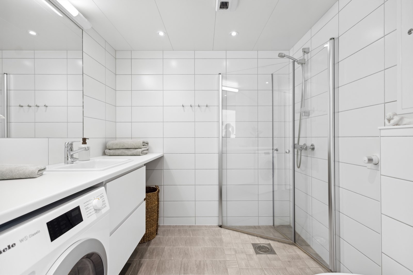 Det delikat flislagte badet er fra byggeår i 2019, og har downlights i tak, varmekabler i gulv, og opplegg for vaskemaskin Galleribilde