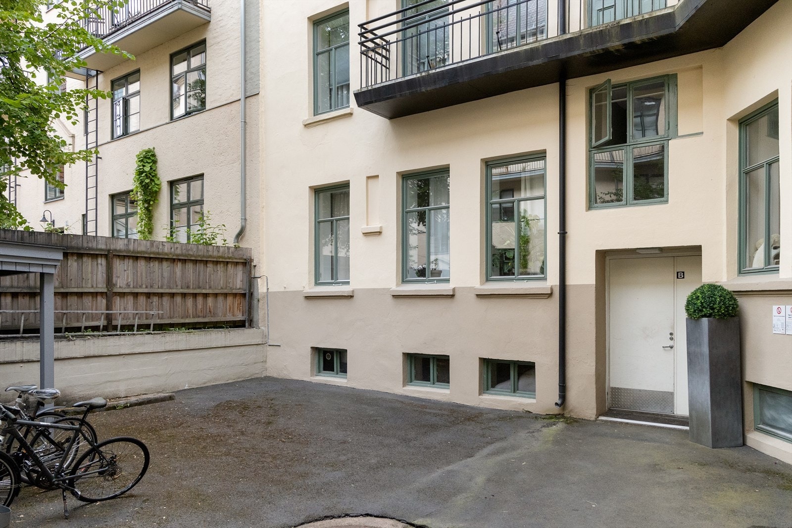 Borettslaget har en asfaltert bakgård med sykkelparkering Galleribilde