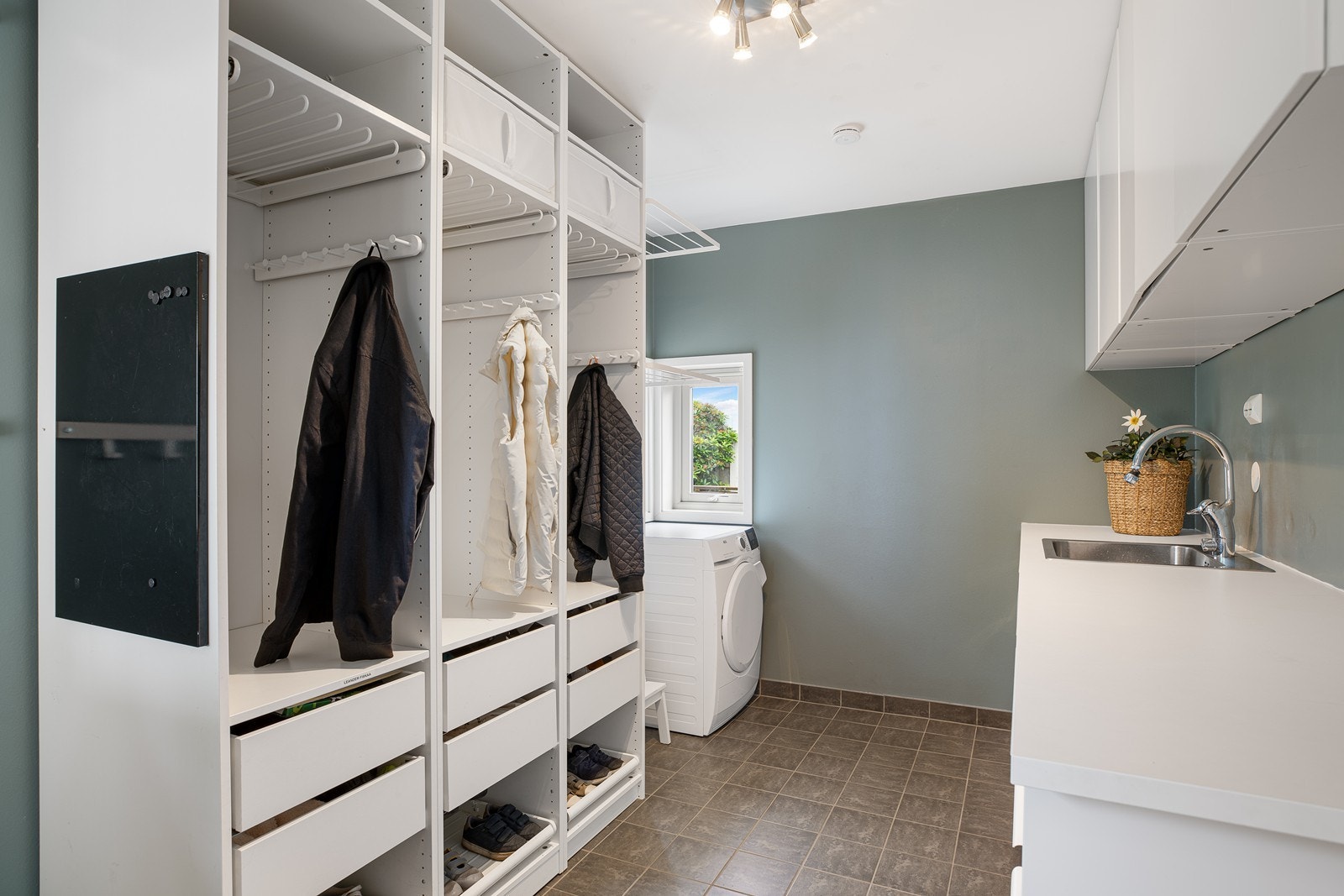 Praktisk vaskerom med fliser på gulv og overflater av malte plater. Varmekabler i gulv Galleribilde