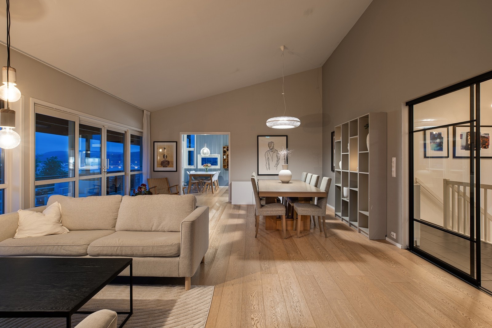 Stuens utforming er sjenerøs og smart, med naturlig definerte soner som inviterer til både avslapning og sosiale samlinger Galleribilde