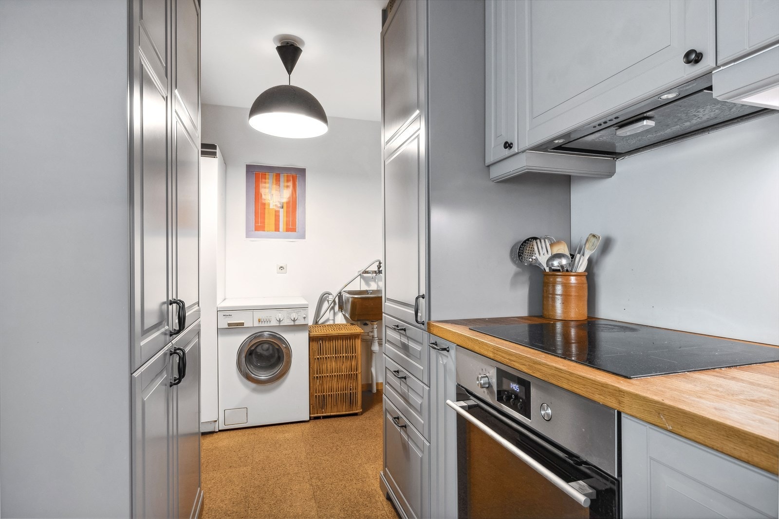 Det er et lite grovkjøkken/vaskeromsdel ved kjøkkenet hvor det er montert utslagsvask, tørkeskap og opplegg for vaskemaskin i rommet. Galleribilde