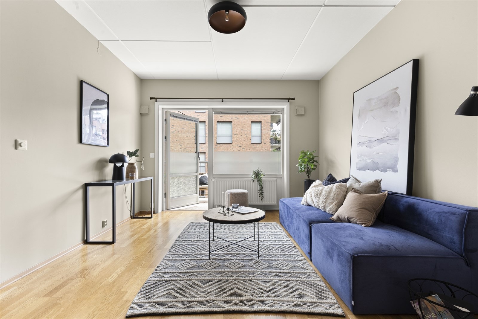 En lys stue med god plass til sofa, spisebord og annet møblement Galleribilde