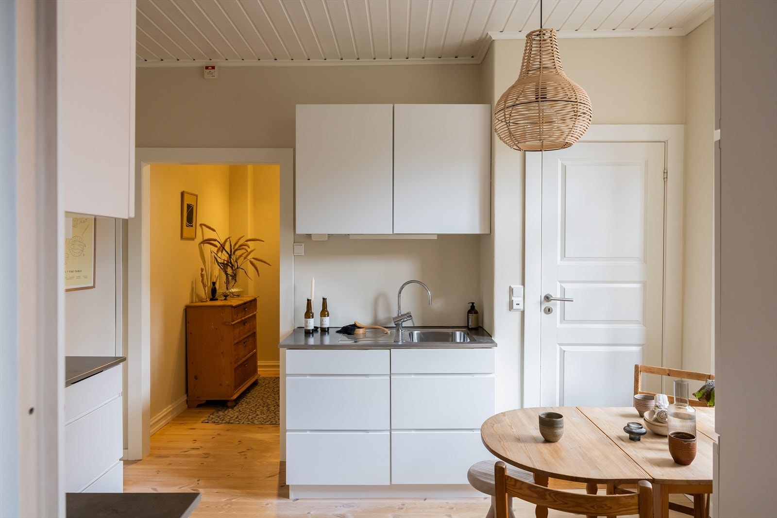 Kjøkkeninnredning med slette fronter og laminert benkeplate med planlimt stålkum. Integrert i innredningen er platetopp, stekeovn og kjøl/frys. Nisje til oppvaskmaskin. Galleribilde