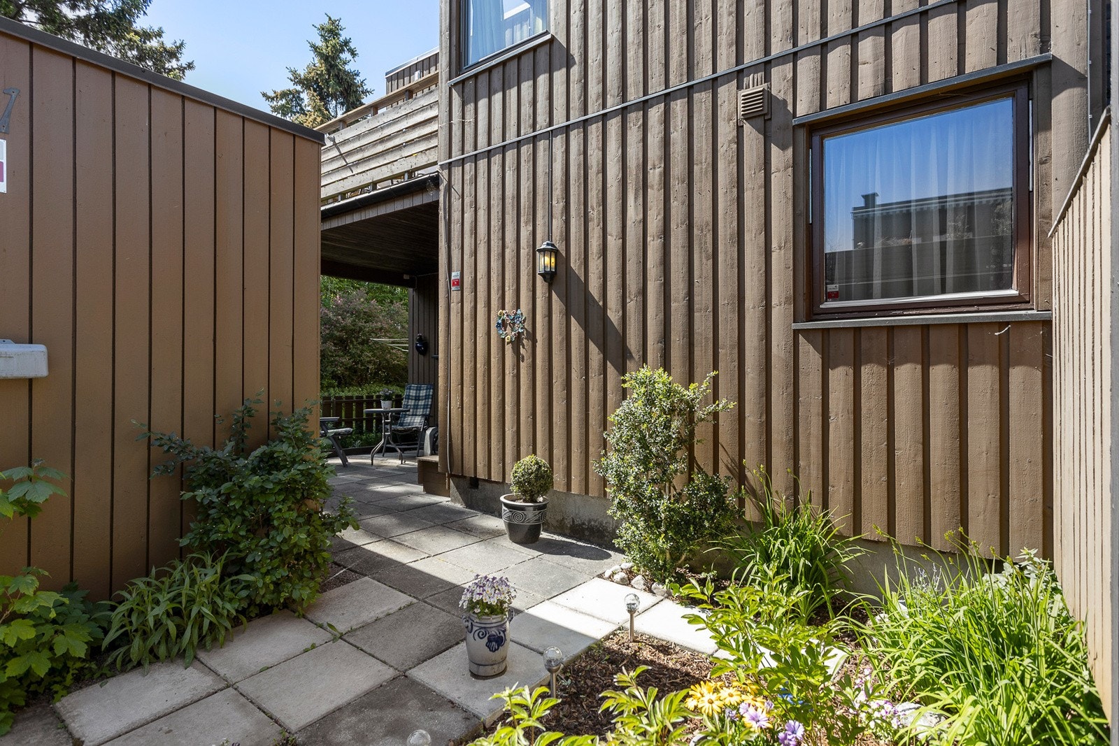 Inngangsparti med beplantning og heller Galleribilde