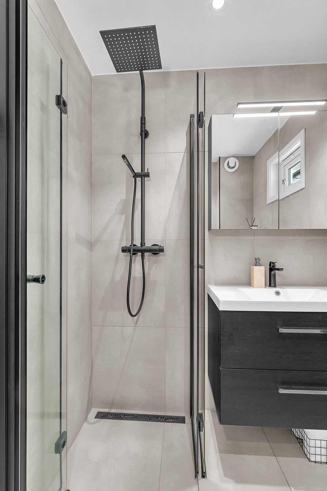 Badet er gjennomført i en flott moderne finish, de sorte detaljer passer veldig godt inn med farger på fliser og tak. Galleribilde