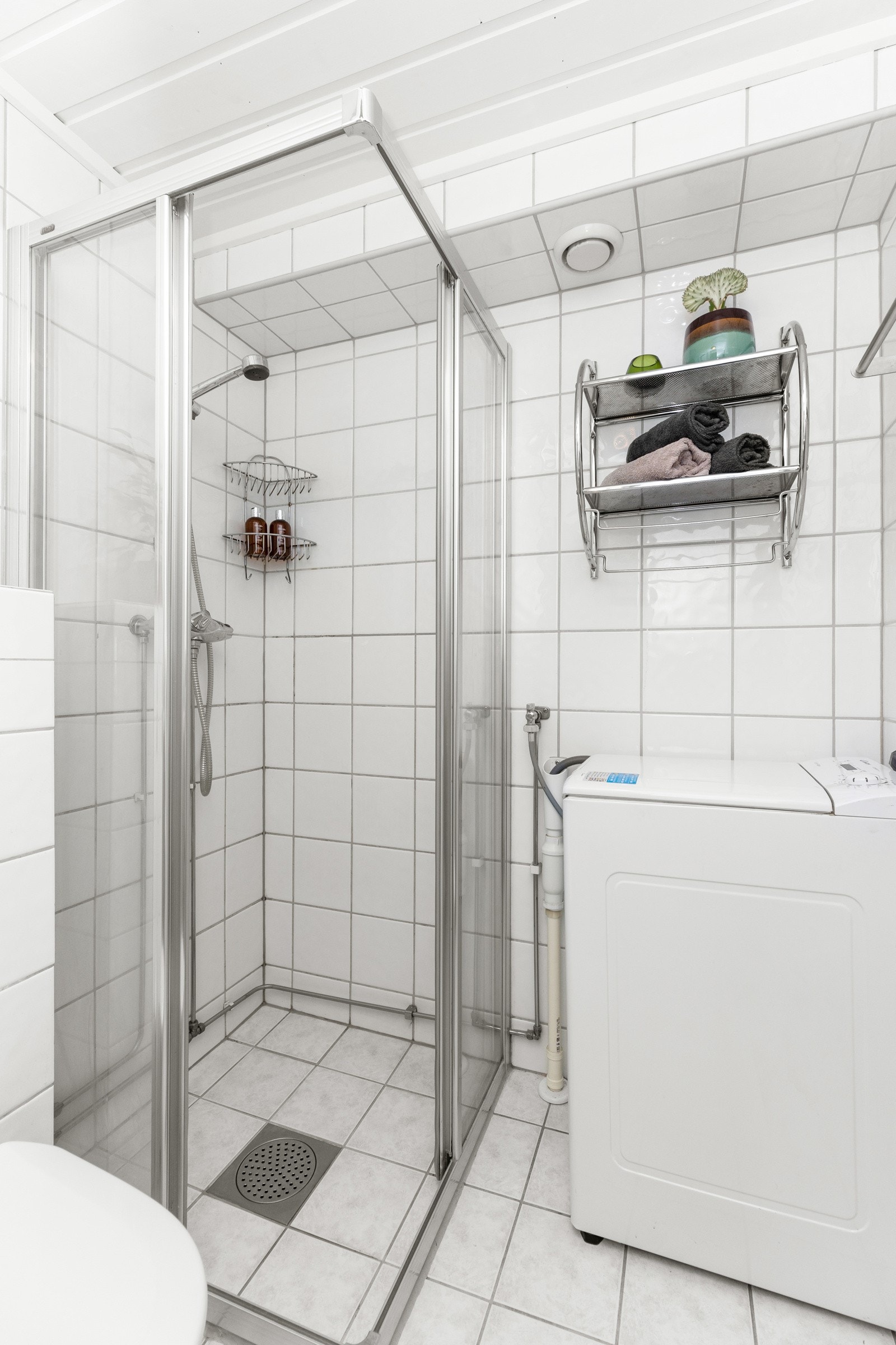 Bad har innredning med servant og speil, dusj, wc og vaskemaskin Galleribilde
