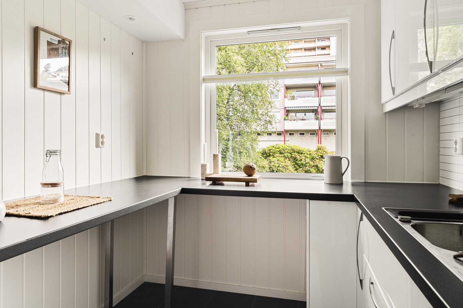 Innredningen er levert av IKEA og består av slette hvite fronter og en slitesterk laminat benkeplate med underlimt vask av stål. Galleribilde