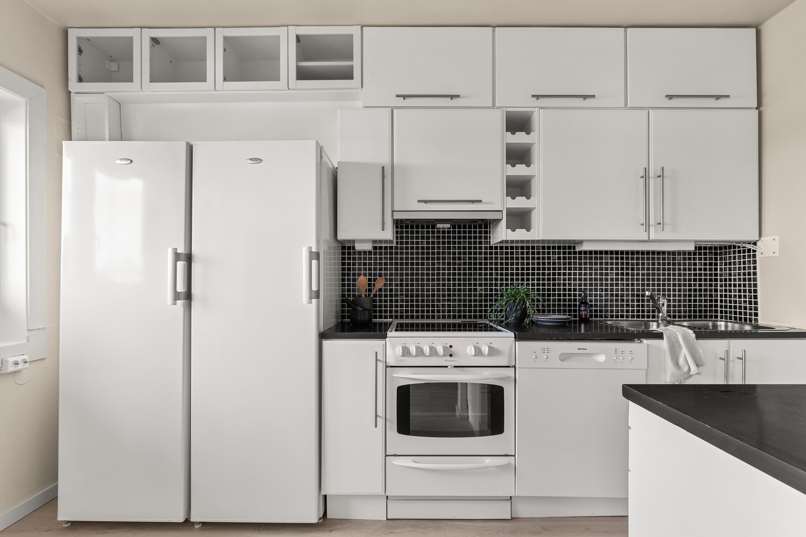 Kjøkkeninnredningen er av slette fronter og benkeplate i laminat med nedfelt kum i rustfritt stål. Kjøkkenet har frittstående hvitevarer. Komfyr, vifte og oppvaskmaskin medfølger. Galleribilde