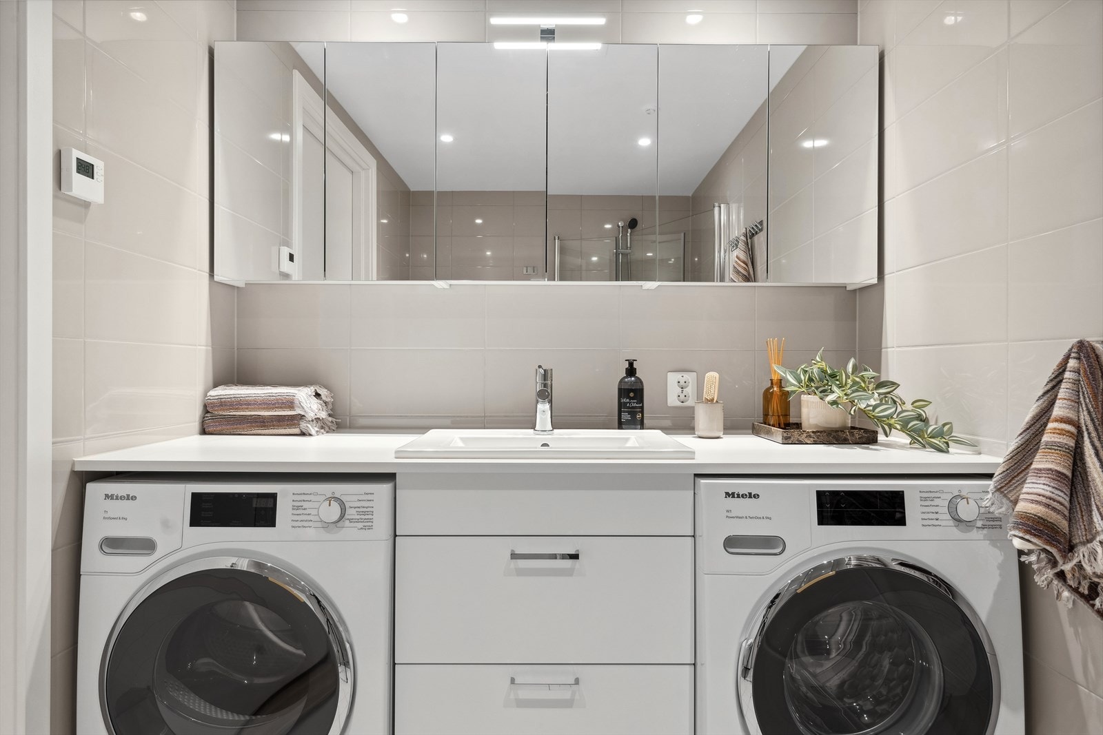 Innredningen er både moderne og funksjonell, med slette fronter og en nedsenket servant utstyrt med et praktisk ett-greps blandebatteri og avløpsrør av slitesterk plast. Her er det også praktisk opplegg for både vaskemaskin og tørketrommel. Galleribilde