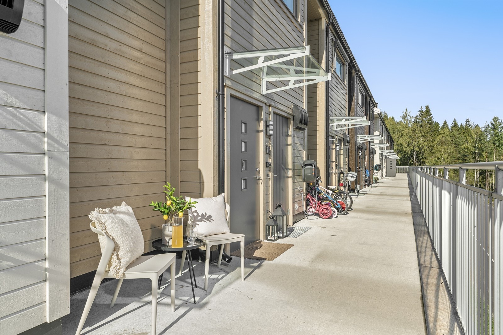 Innbydende inngangsparti via svalgang. Her ute er det plass til å sette stoler og bord. Ved ytterdøren er det også inngang til en utvendig sportsbod med ekstra lagringsplass. Galleribilde