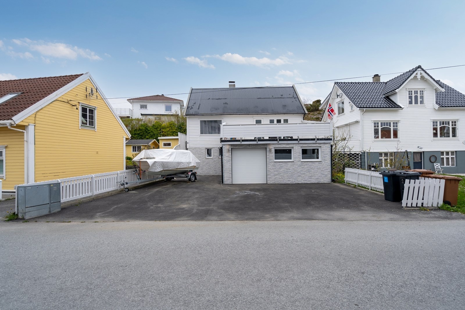 Stort asfaltert gårdsrom med god plass til flere biler, båt og port til innvendig garasje. Galleribilde