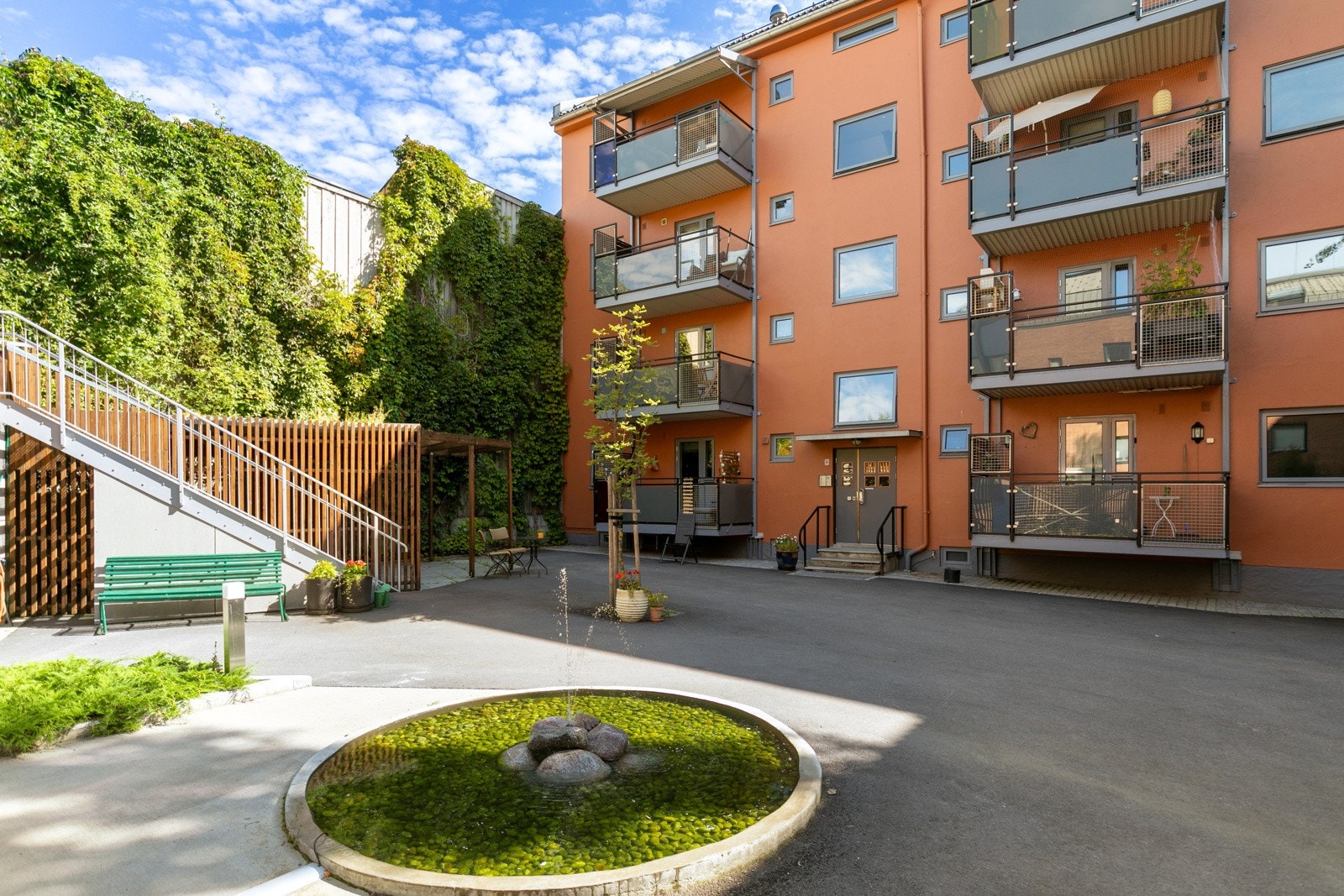 Den flotte bakgården byr på takterrasse, sykkelparkering, beplantning, fontene og flere innbydende sittegrupper Galleribilde