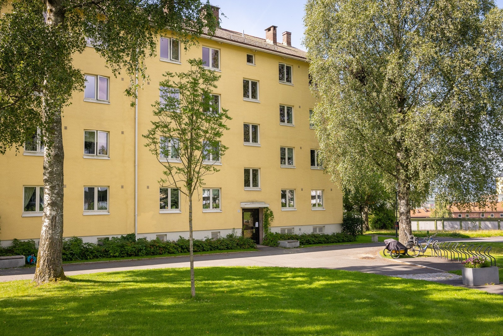 Sykkeloppbevaring i kjeller, via sykkelskur mot Grenseveien samt mulighet for å leie plass i en omdisponert garasje for tyngre sykler. Galleribilde