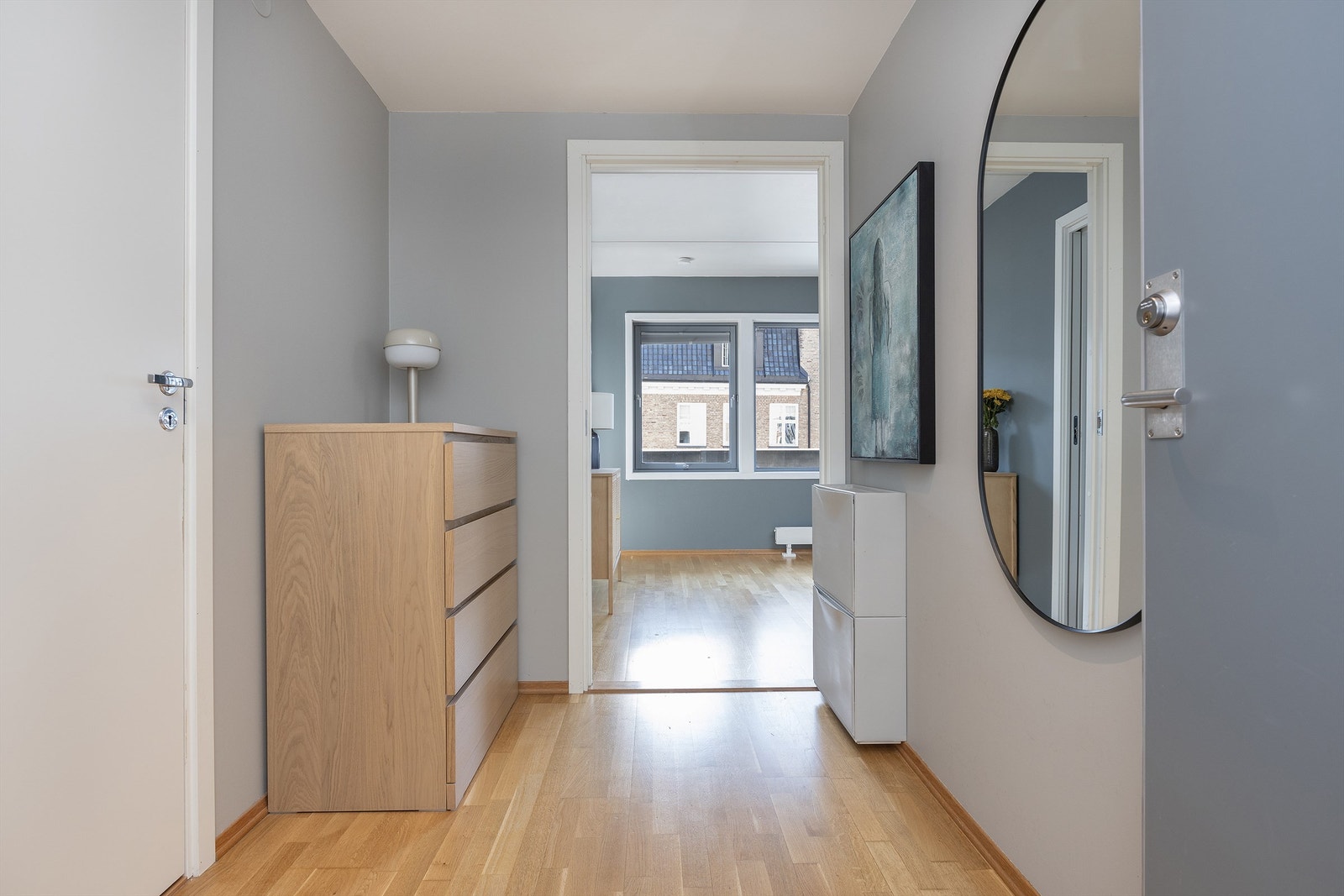 Innbydende entré med plass til oppheng av tøy og oppbevaring av sko. Plass til blant annet kommoder/skap. Parkett på gulv Galleribilde